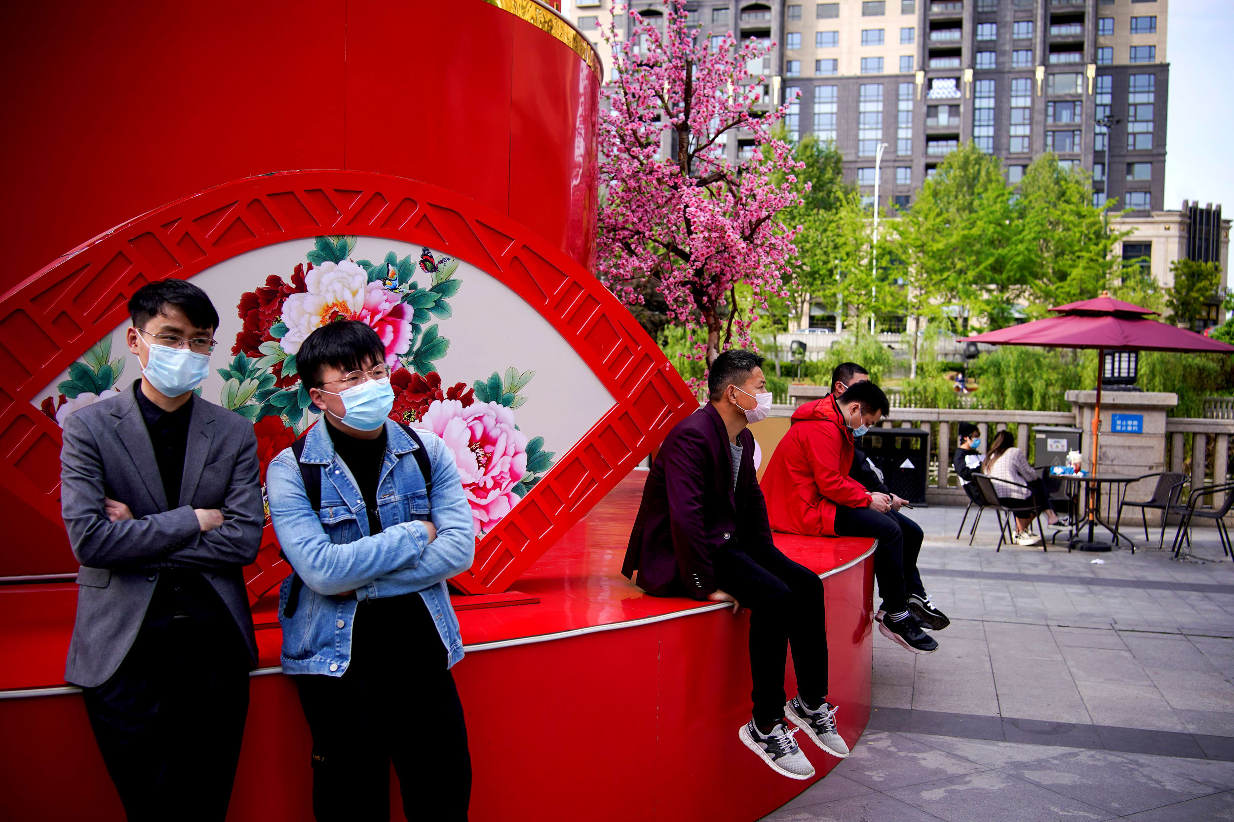 Image: People gather near a shopping area as the city of Wuhan springs back to life on Tuesday. 