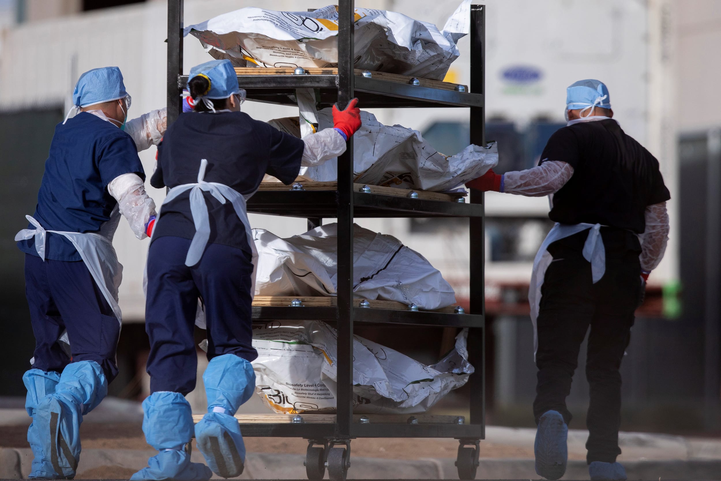 Image: El Paso County Medical Examiner's Office staff move bodies in El Paso