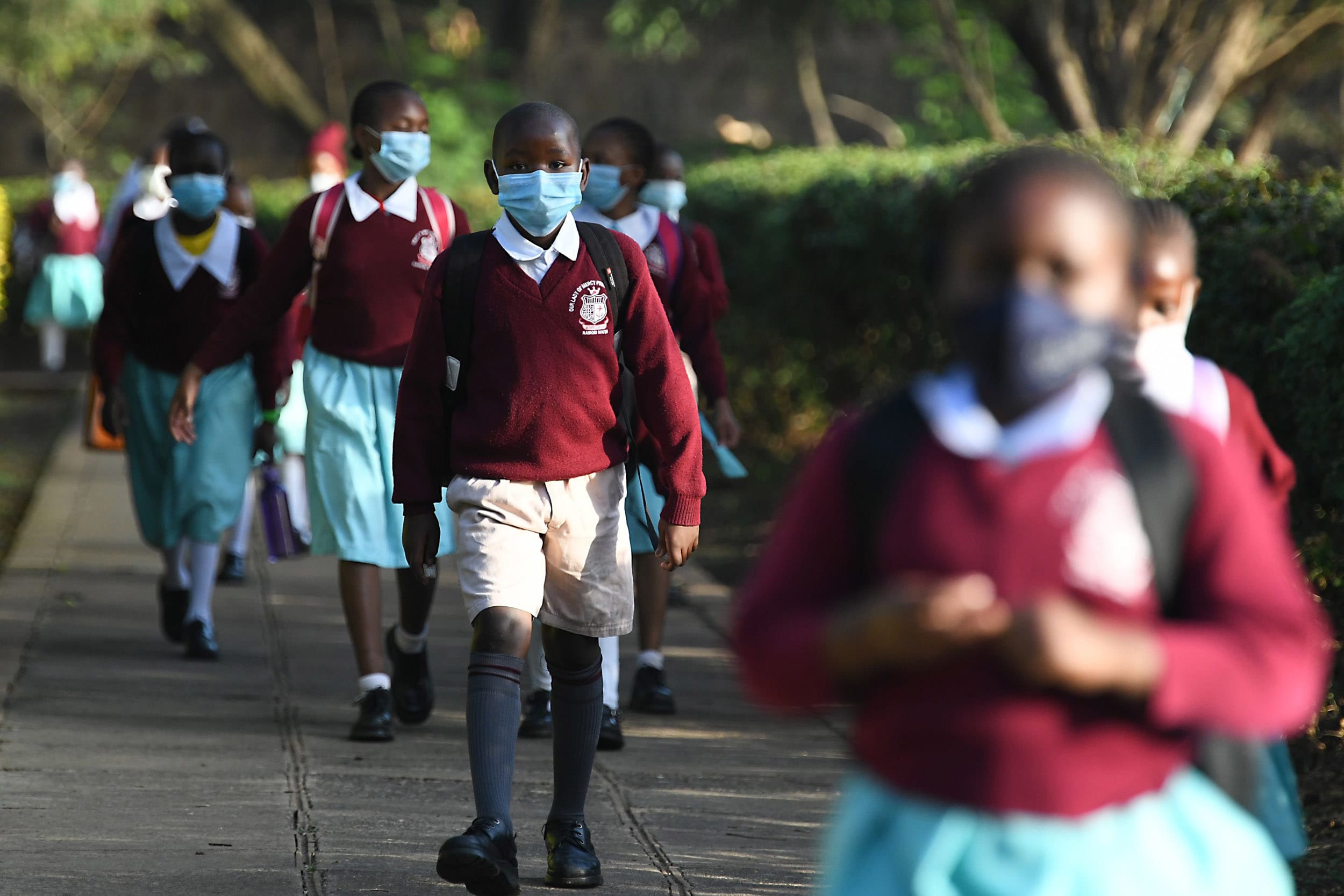 Image: Kenyan school children wear face masks while walking to school as they resume in-class learning after a nine-month disruption caused by the Covid-19 coronavirus pandemic, in Nairobi