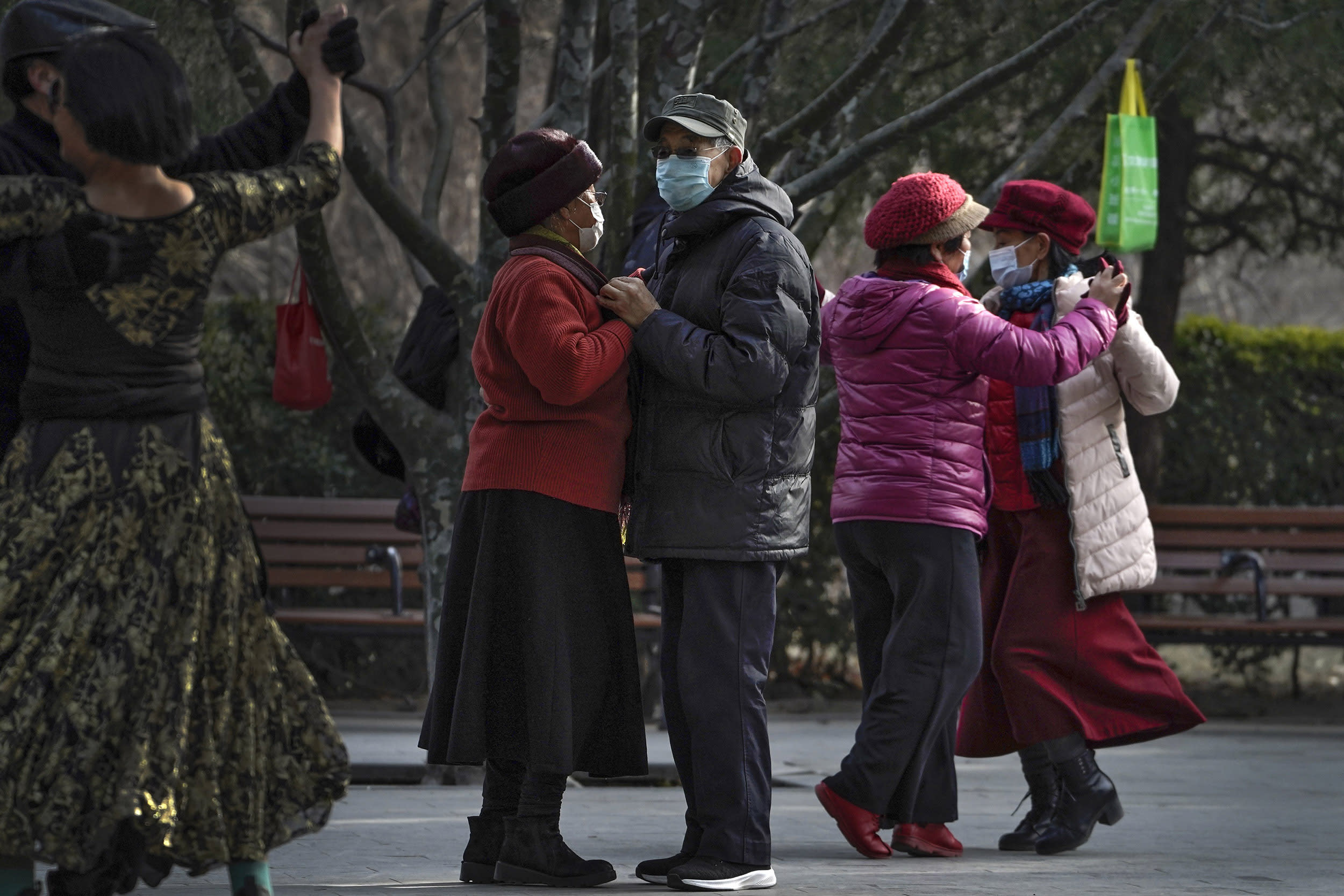 Image: People wearing face masks to help curb the spread of the coronavirus enjoy a social dance at a public park in Beijing