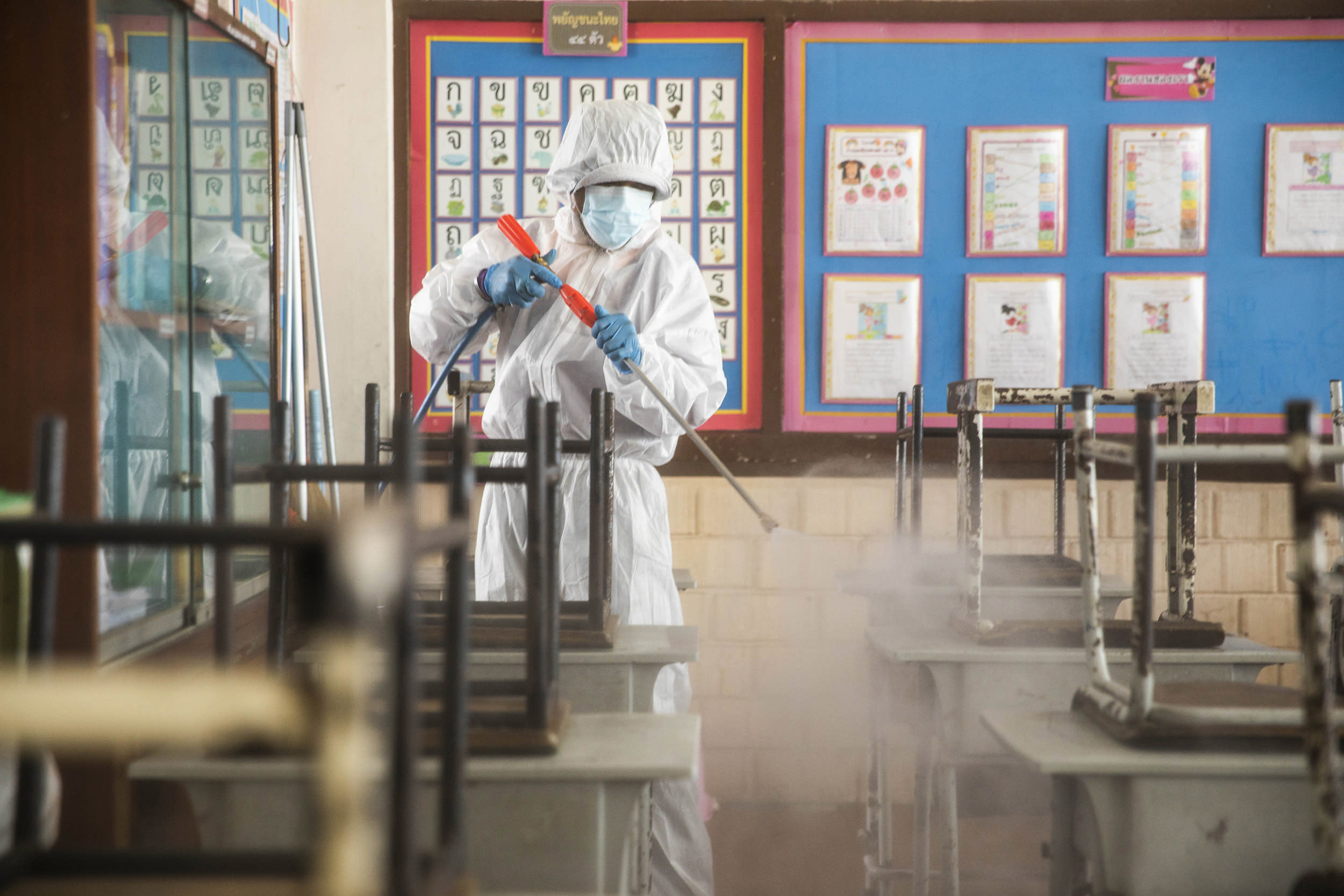 Image: Members of the Bangkok Metropolitan Authority wear PPE as they sanitize classrooms in the San Chao Elementary School