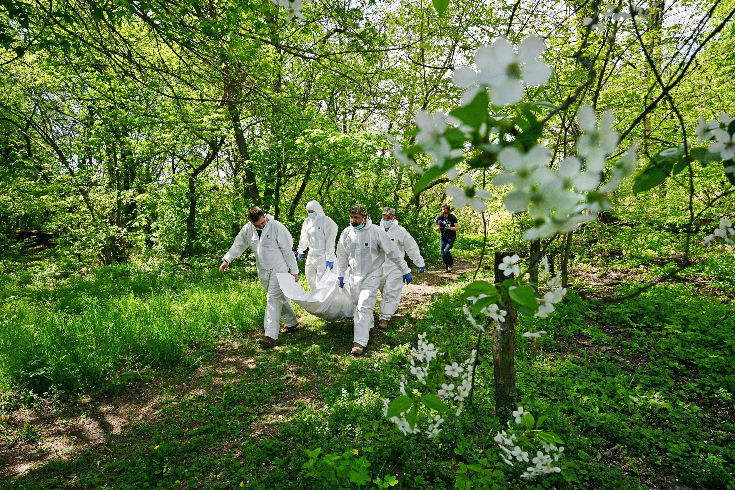 Ukrainian forensics experts carry the body of a Russian soldier