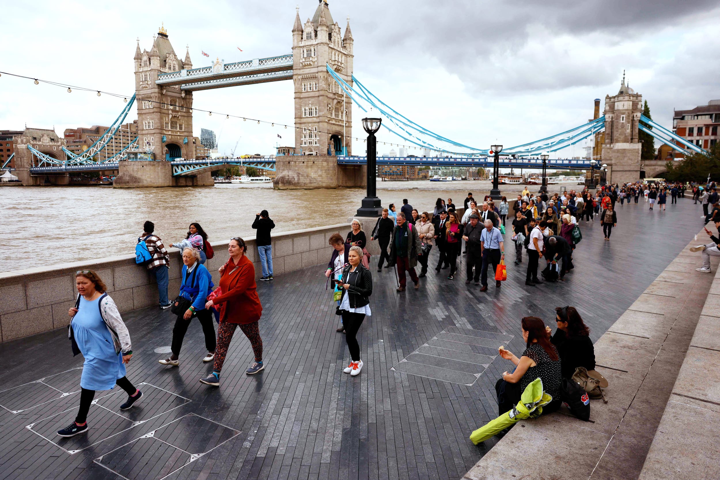 Members of the public stand in the queue on the South Bank of the River Thames