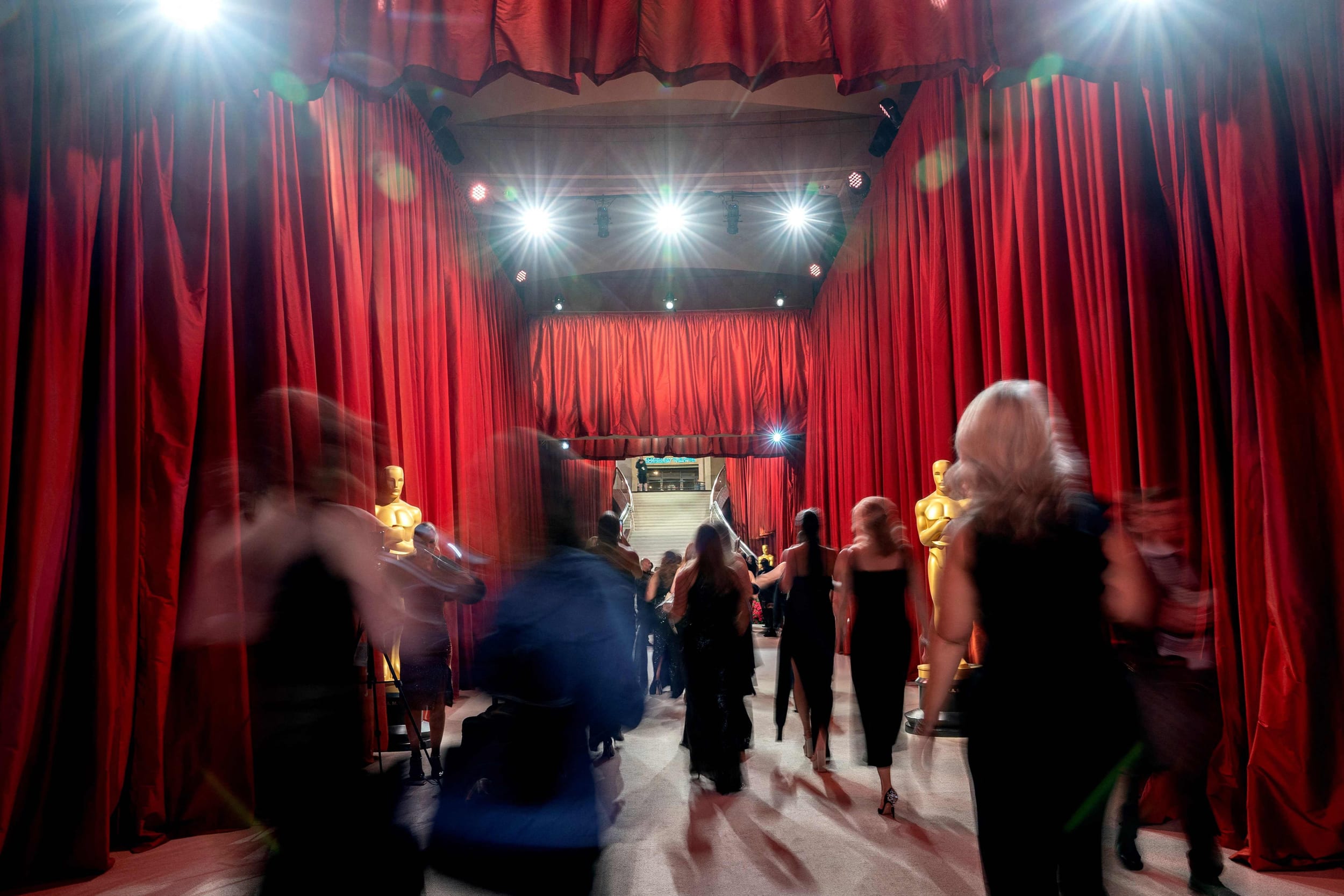 People walk along the champagne carpet ahead of the Academy Awards in Hollywood, Calif.