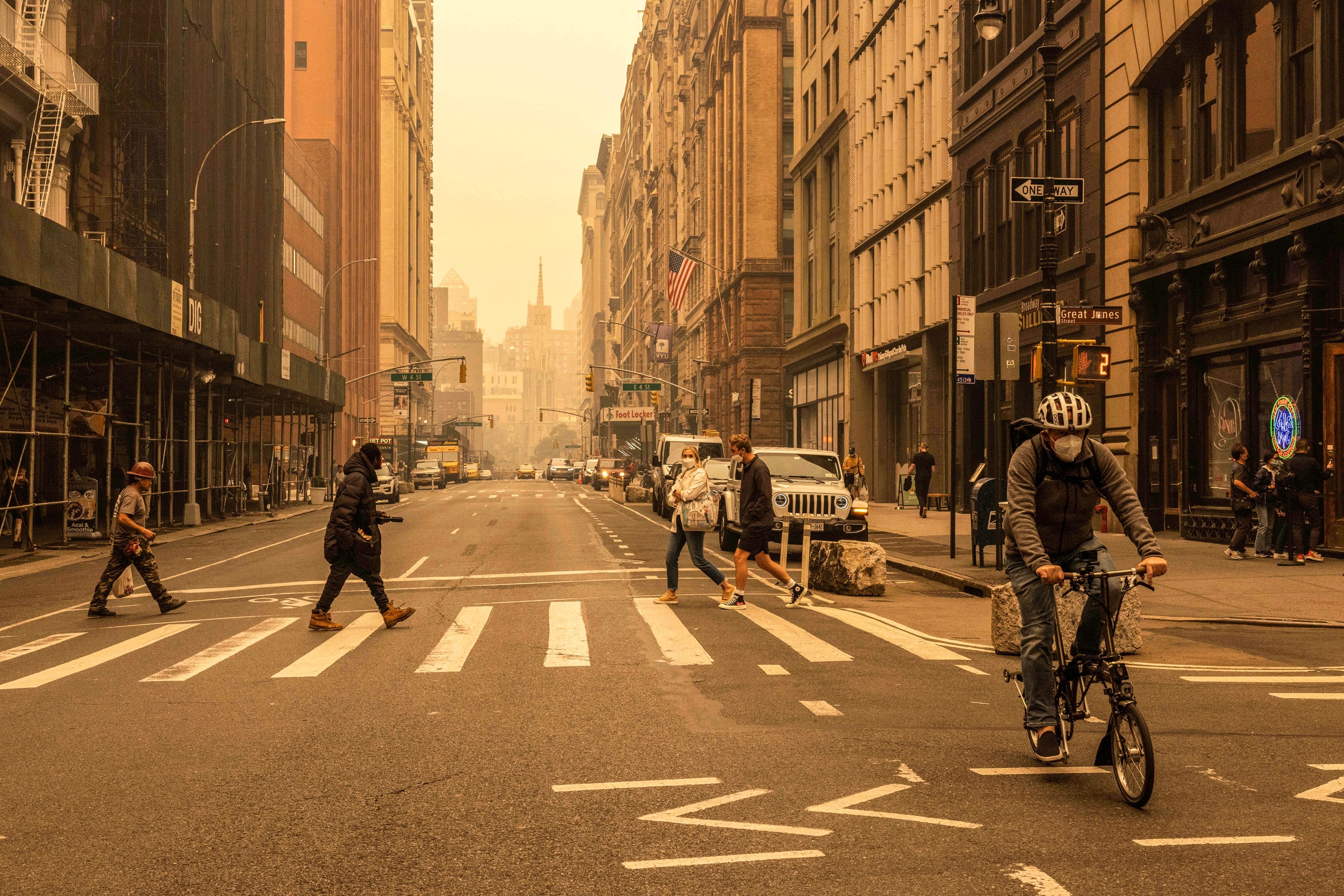 Pedestrians wear face masks as smoke from Canada wildfires blankets New York on June 7, 2023.