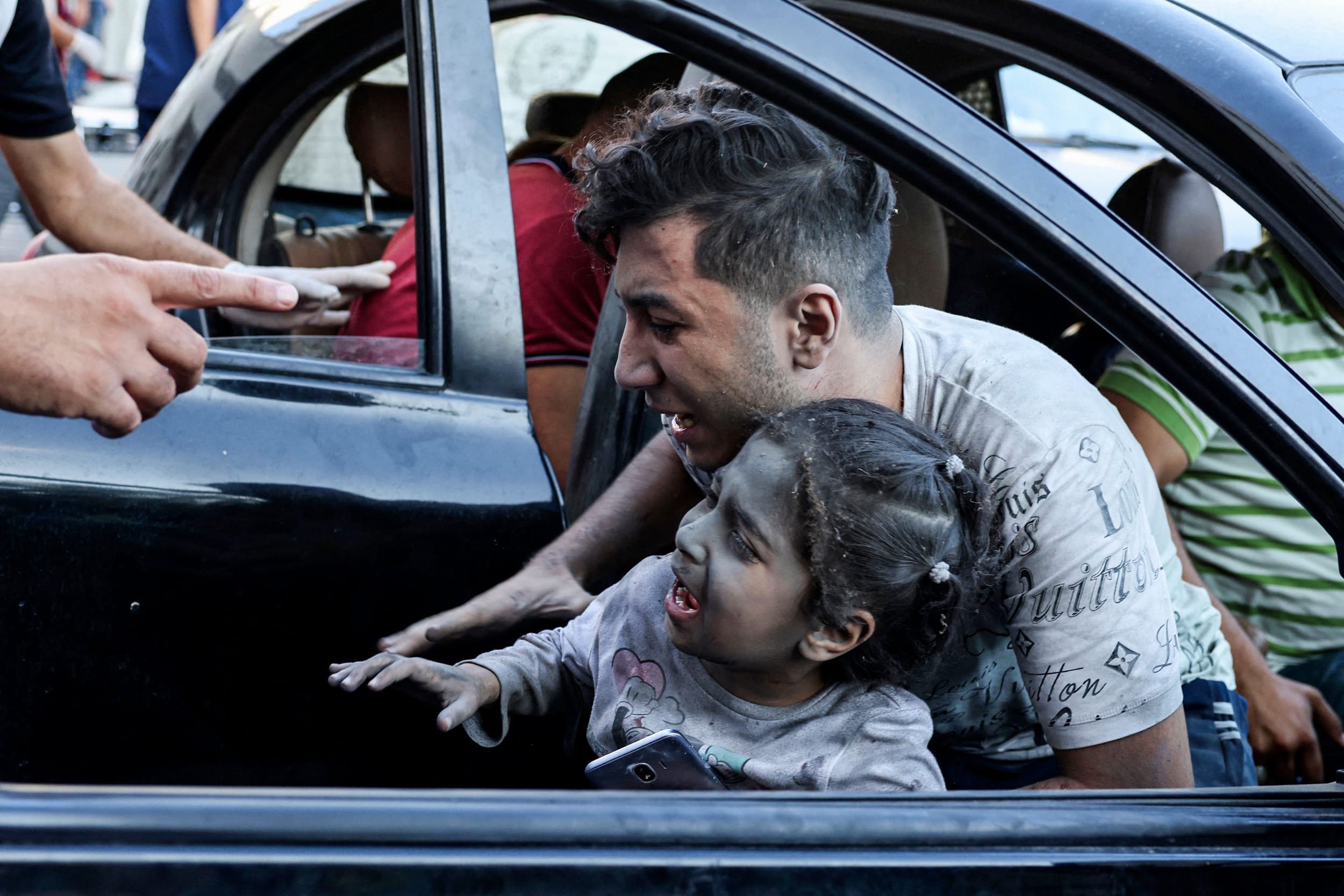 A man carries a wounded child to al-Shifa hospital in Gaza.