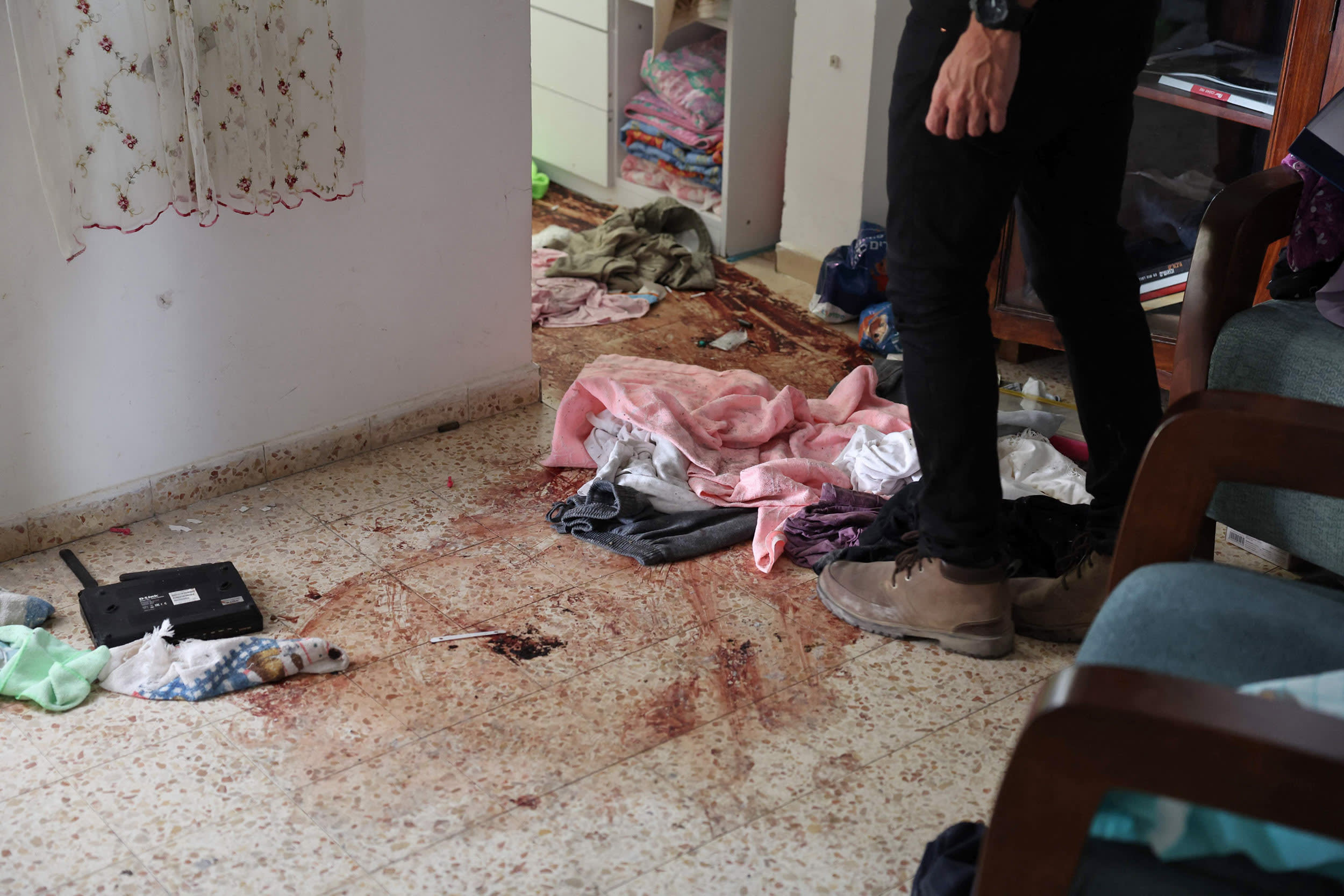 A man checks blood stains on the floor of a house inside the kibbutz Nir Oz along the border with the Gaza Strip on Oct. 19, 2023.