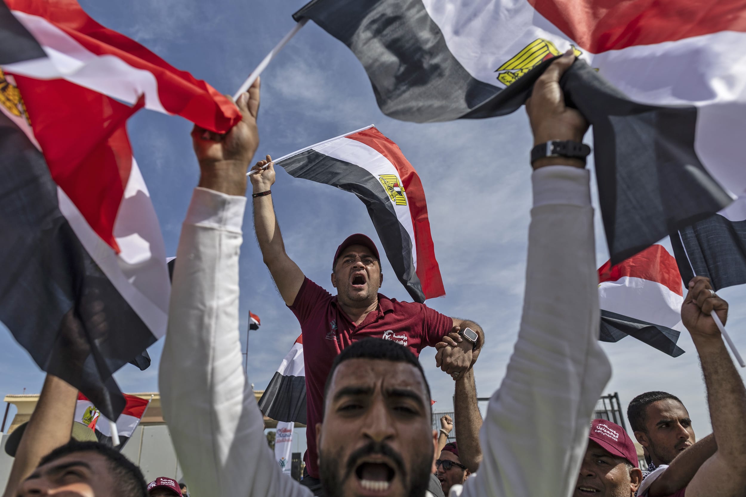 Volunteers and NGO staff celebrate after unloading aid supplies in Gaza and returning to the Egyptian side of the border on Oct. 21, 2023 in North Sinai.