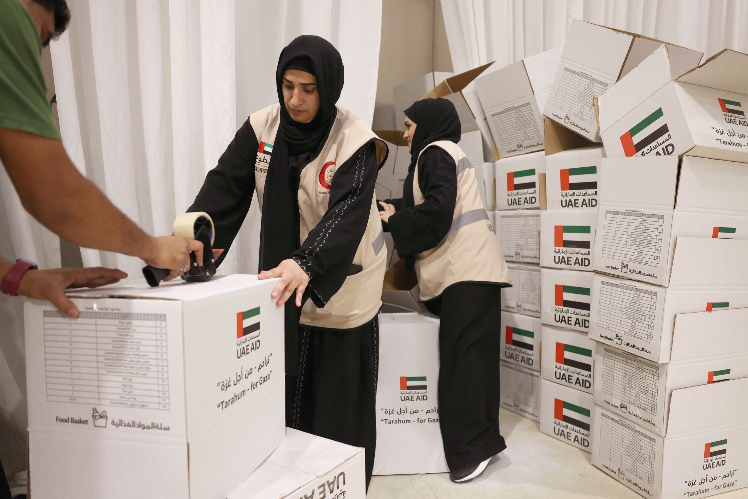 People construct boxes to be filled with aid at a donation center
