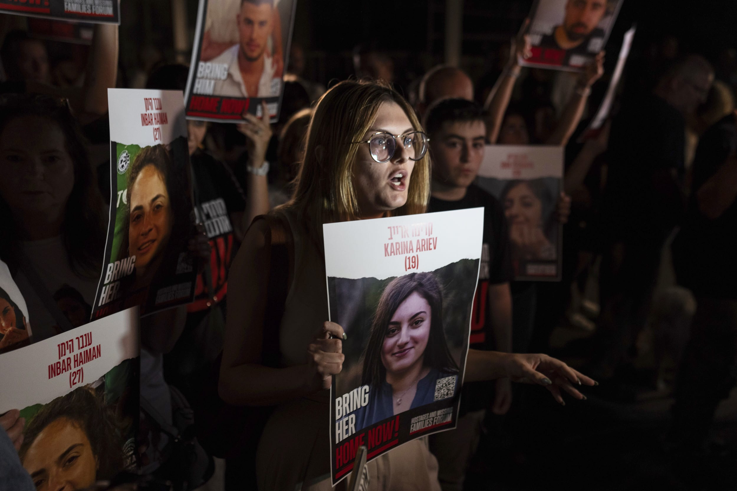 Relatives of people kidnapped by Hamas militants hold the pictures of their loved ones during a protest