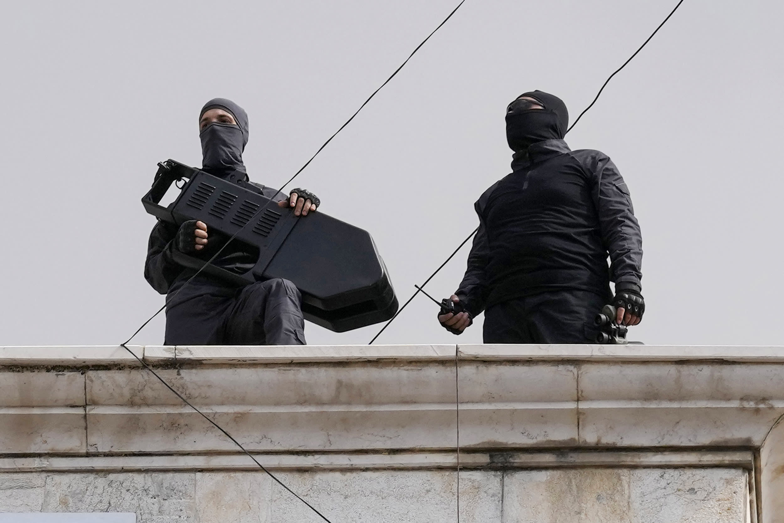 Hezbollah fighters stand guard on a building roof top to protect their supporters during a pro-Palestinian protest in Beirut.