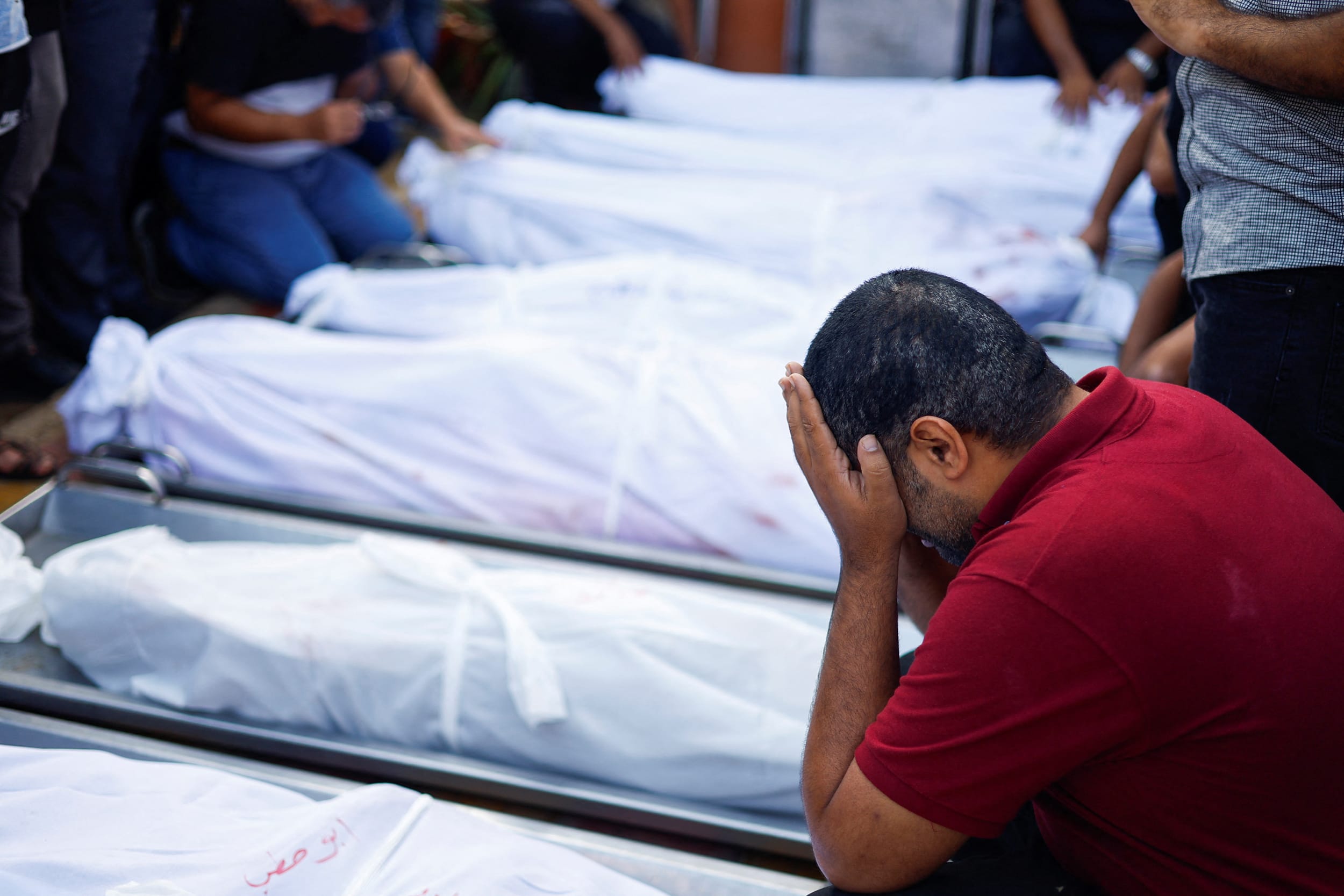 A man reacts next to the bodies of Palestinians killed in Israeli strikes in Khan Younis in the southern Gaza Strip