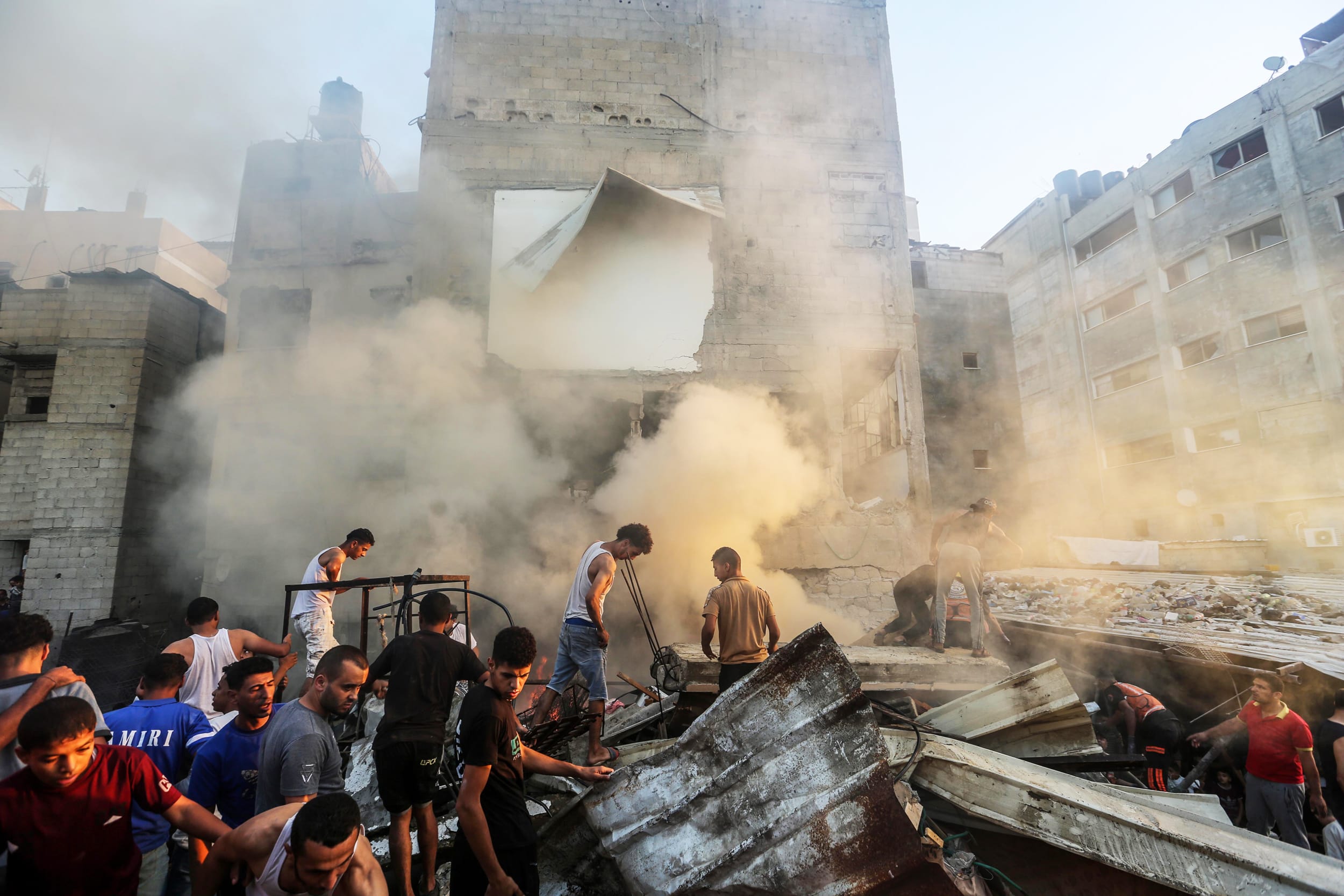 People search through buildings that were destroyed during Israeli air raids