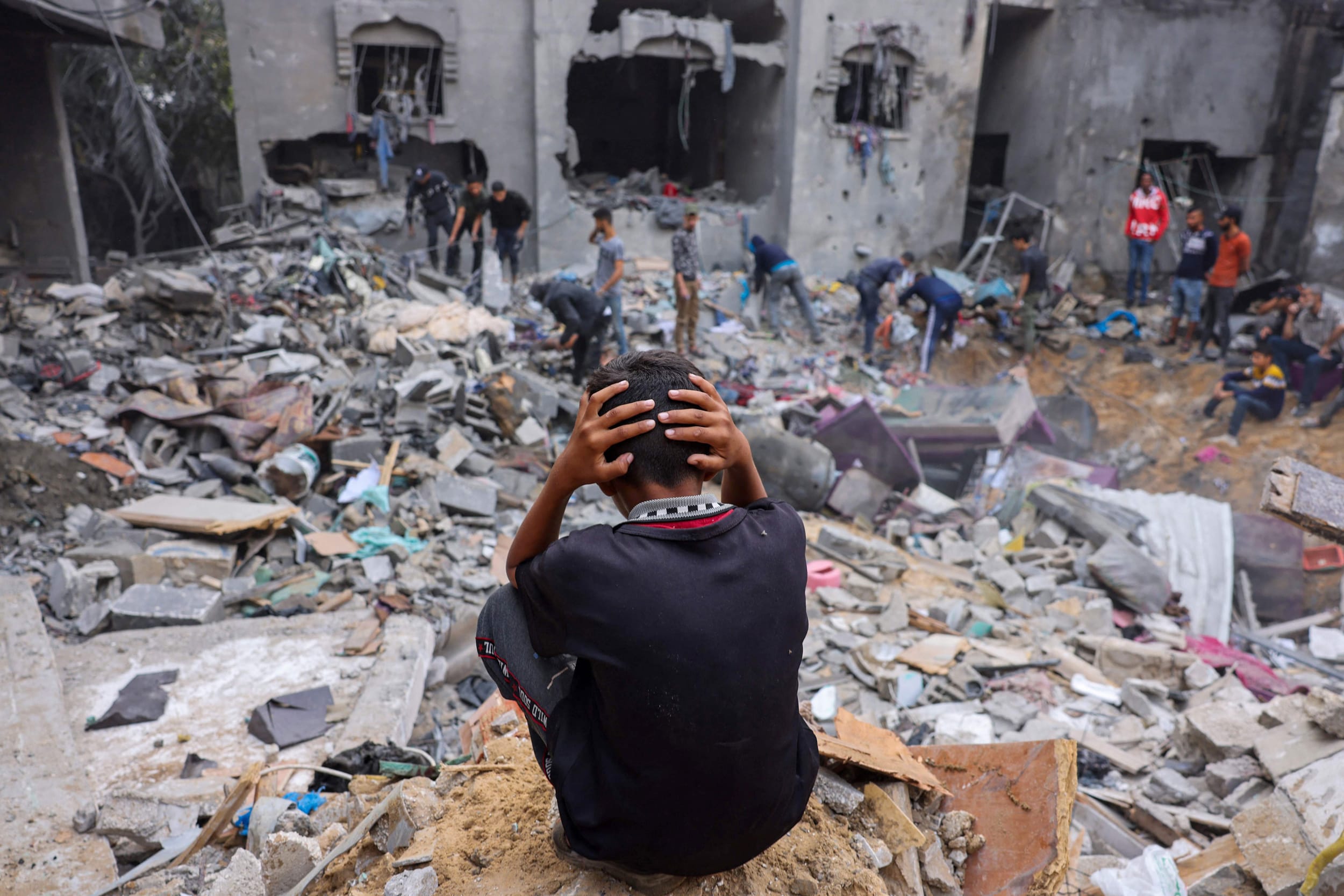A child reacts as people salvage belongings amid the rubble of a damaged building following strikes on Rafah in the southern Gaza Strip, on Nov. 12, 2023.