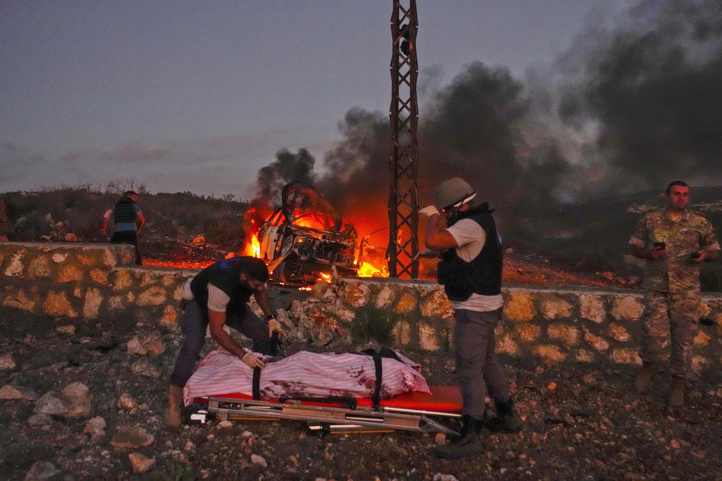 Civil Defense workers remove the body of Reuters videographer Issam Abdallah who was killed by Israeli shelling in south Lebanon on the border with Israel on Oct. 13, 2023. .