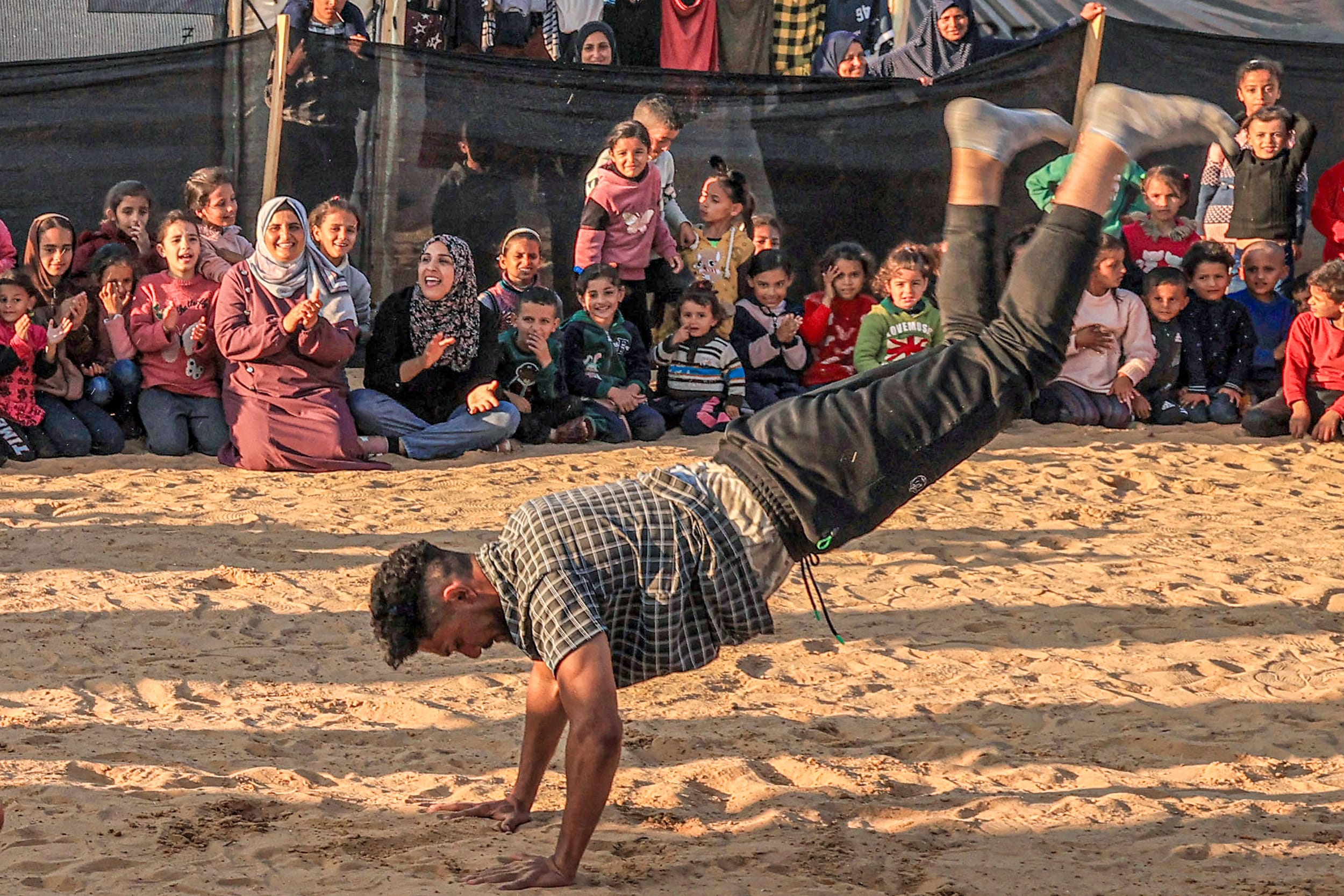 A man performs for children in Rafah, southern Gaza, on De. 18, 2023.
