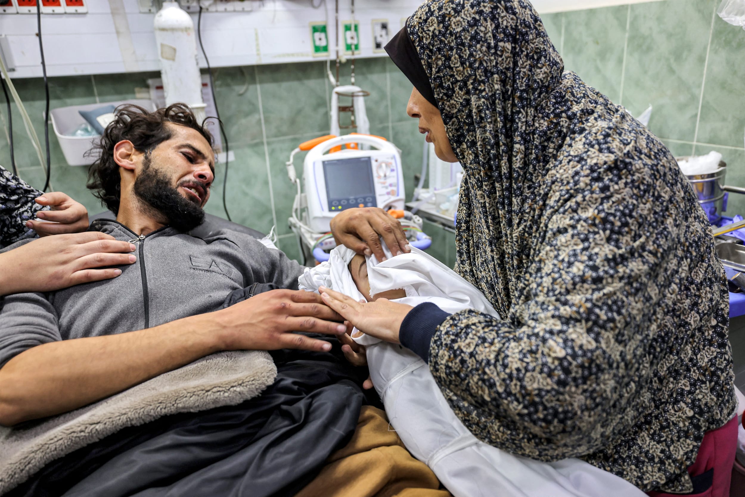 An injured man bids farewell to the body of his son in a hospital in Rafah in the aftermath of overnight Israeli bombardment on Dec. 19, 2023.
