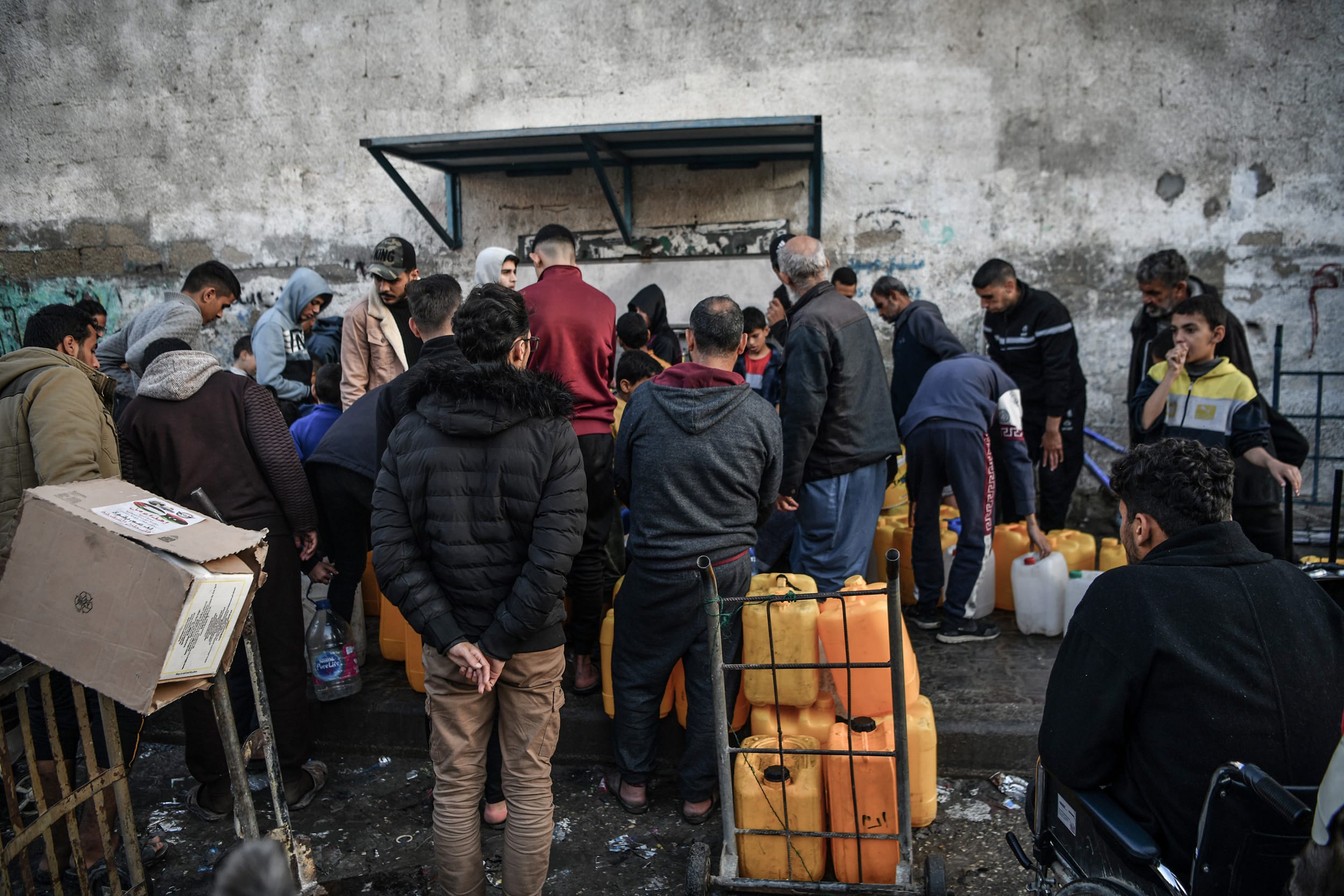 Palestinians wait in line to get clean water from a fountain in Rafah, southern Gaza on Jan. 3, 2024.