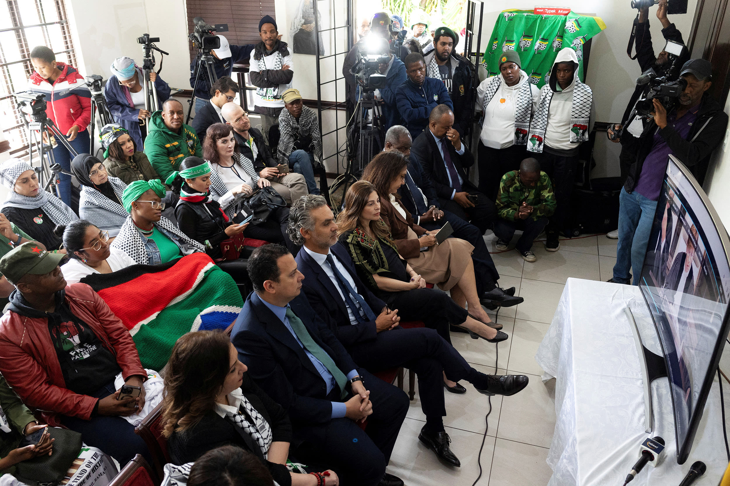 Pro-Palestinian supporters gather to watch the South African Government's genocide case at the International Court of Justice in the Hague, which accuses Israel of genocide in the Gaza war, at the headquarters of the Palestinian mission in Pretoria