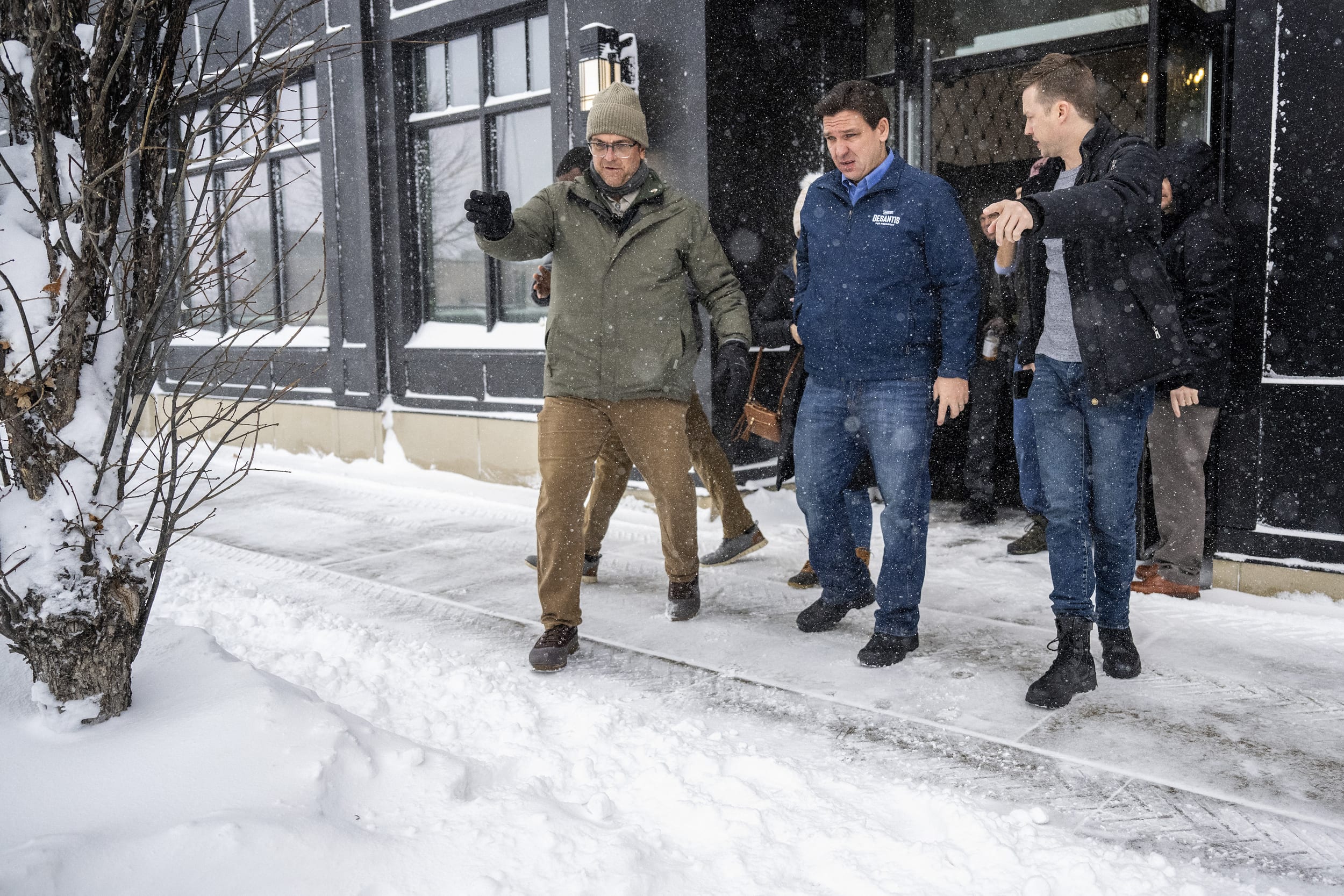 Florida Gov. Ron DeSantis is guided to his vehicle by staff as he departs a campaign stop in Ankeny, Iowa, on Jan. 12, 2024. 