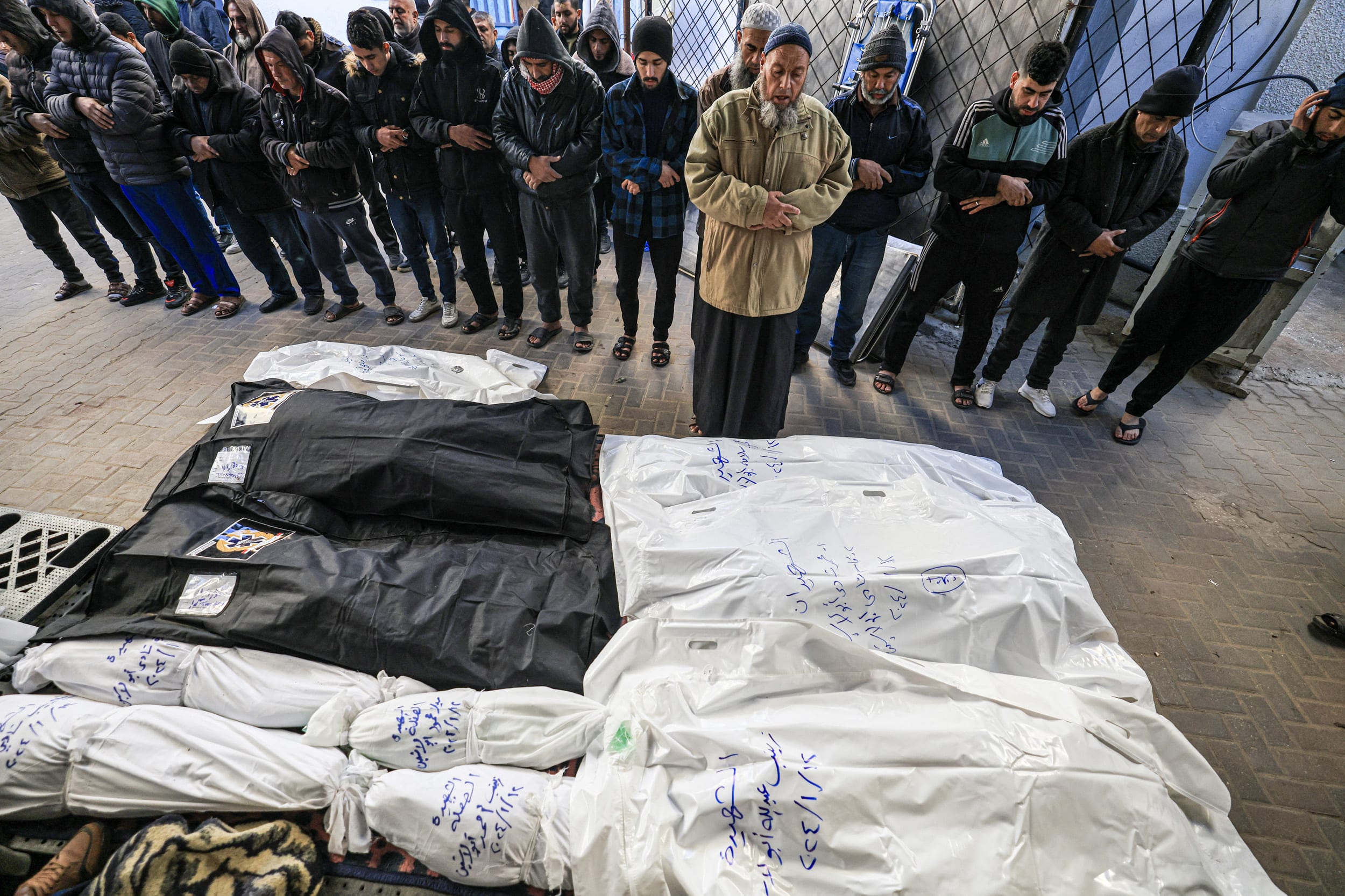 People pray over the shrouded bodies of loved ones on Jan. 13, 2024, at Al-Najjar Hospital in Rafah, southern Gaza.