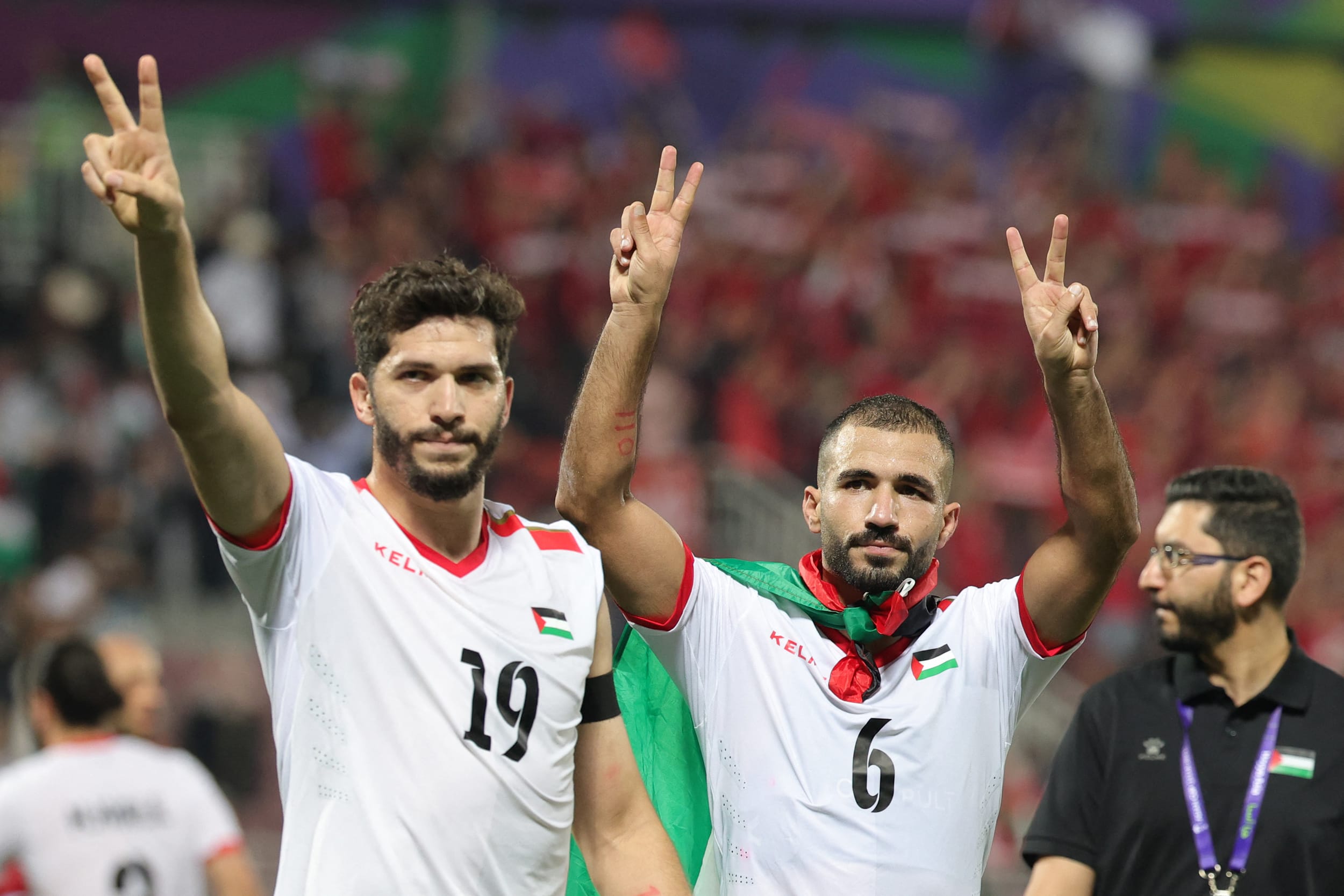 Mahmoud Wadi, left, and Oday Kharoub greet supporters after the Qatar 2023 AFC Asian Cup Group C football match between Hong Kong and Palestine at the Abdullah bin Khalifa Stadium in Doha