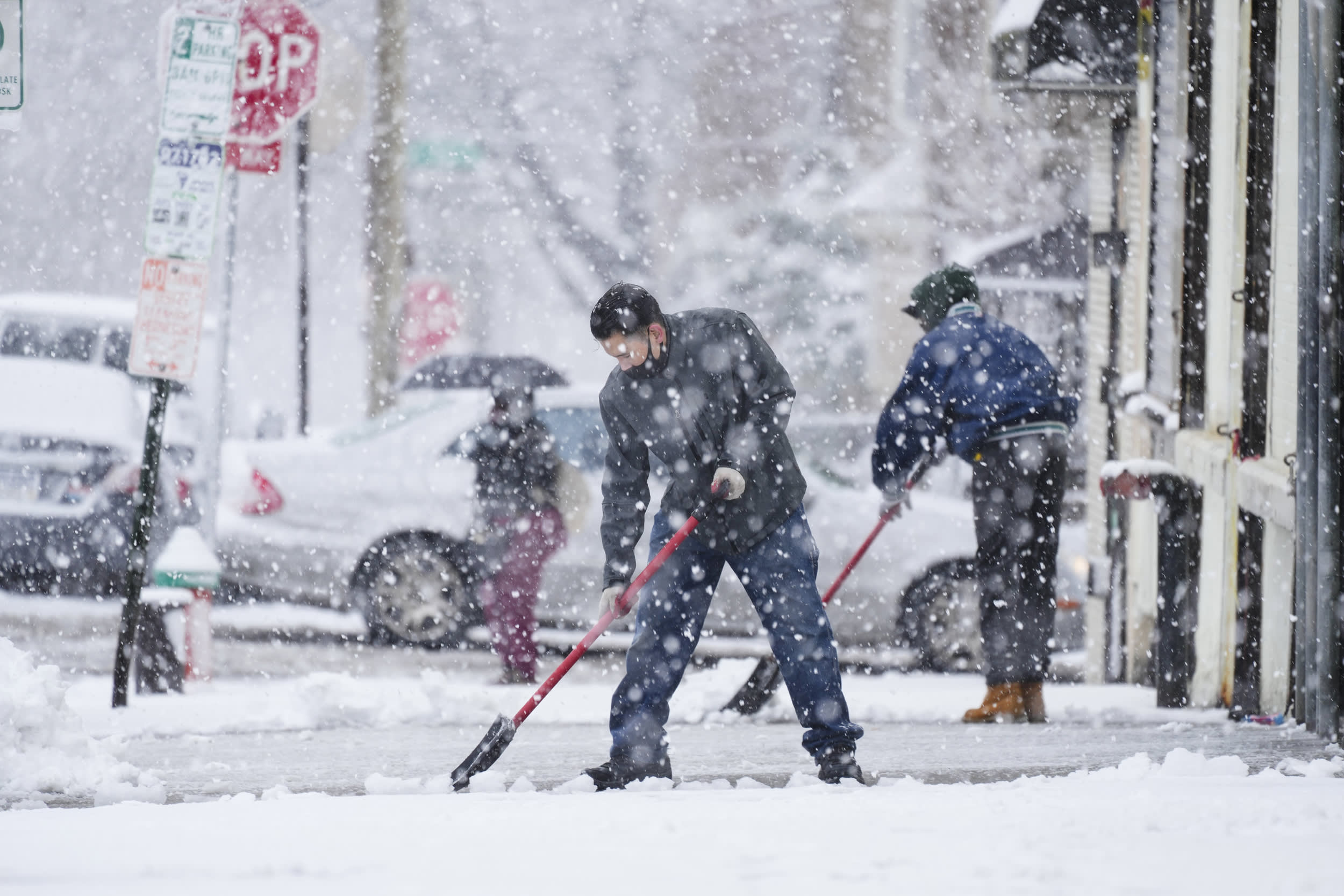 People clear a sidewalk in Philadelphia, Tuesday, Feb. 13, 2024.