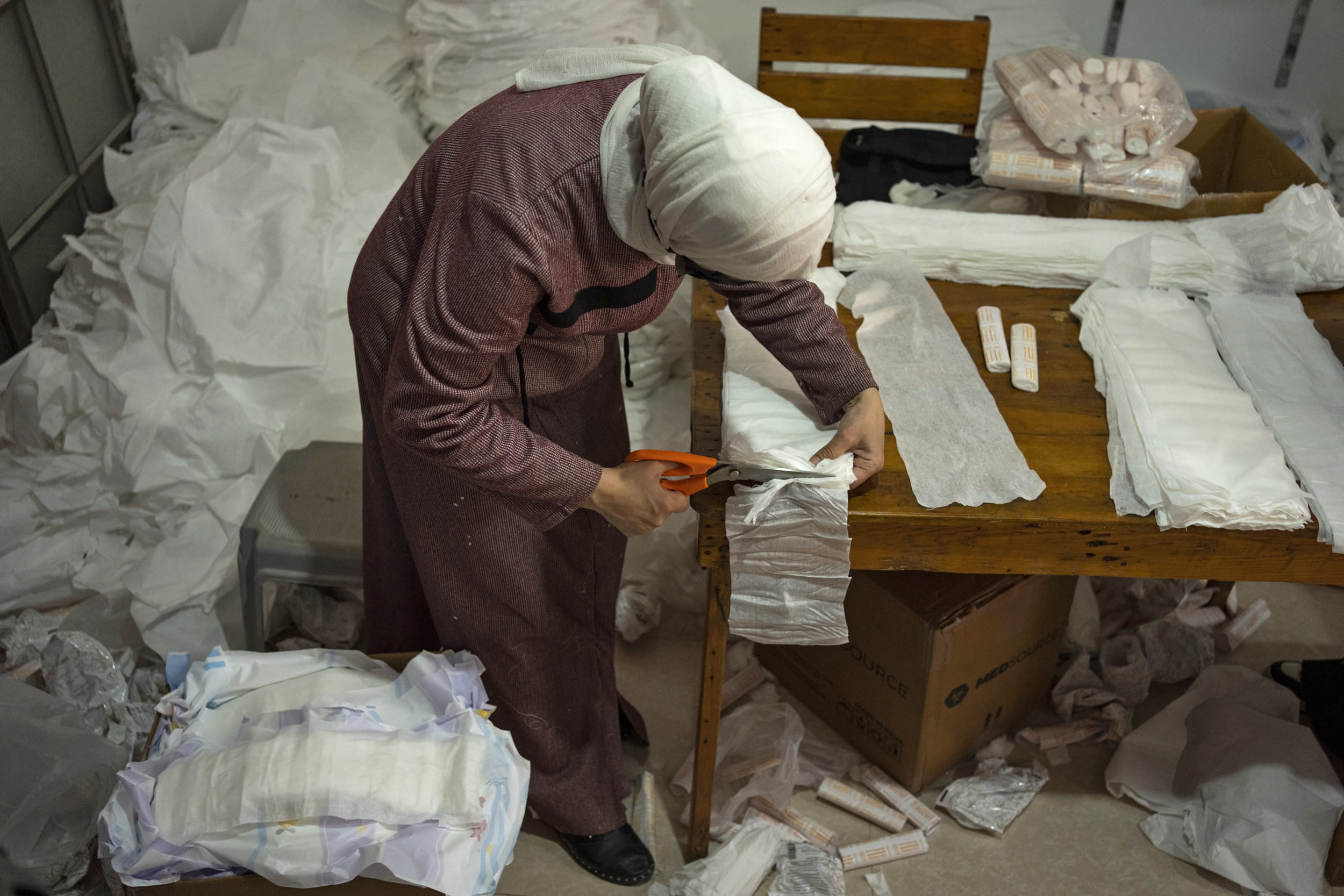 A Palestinian woman sews diapers in Rafah, southern Gaza Strip, Thursday, Feb. 15, 2024.
