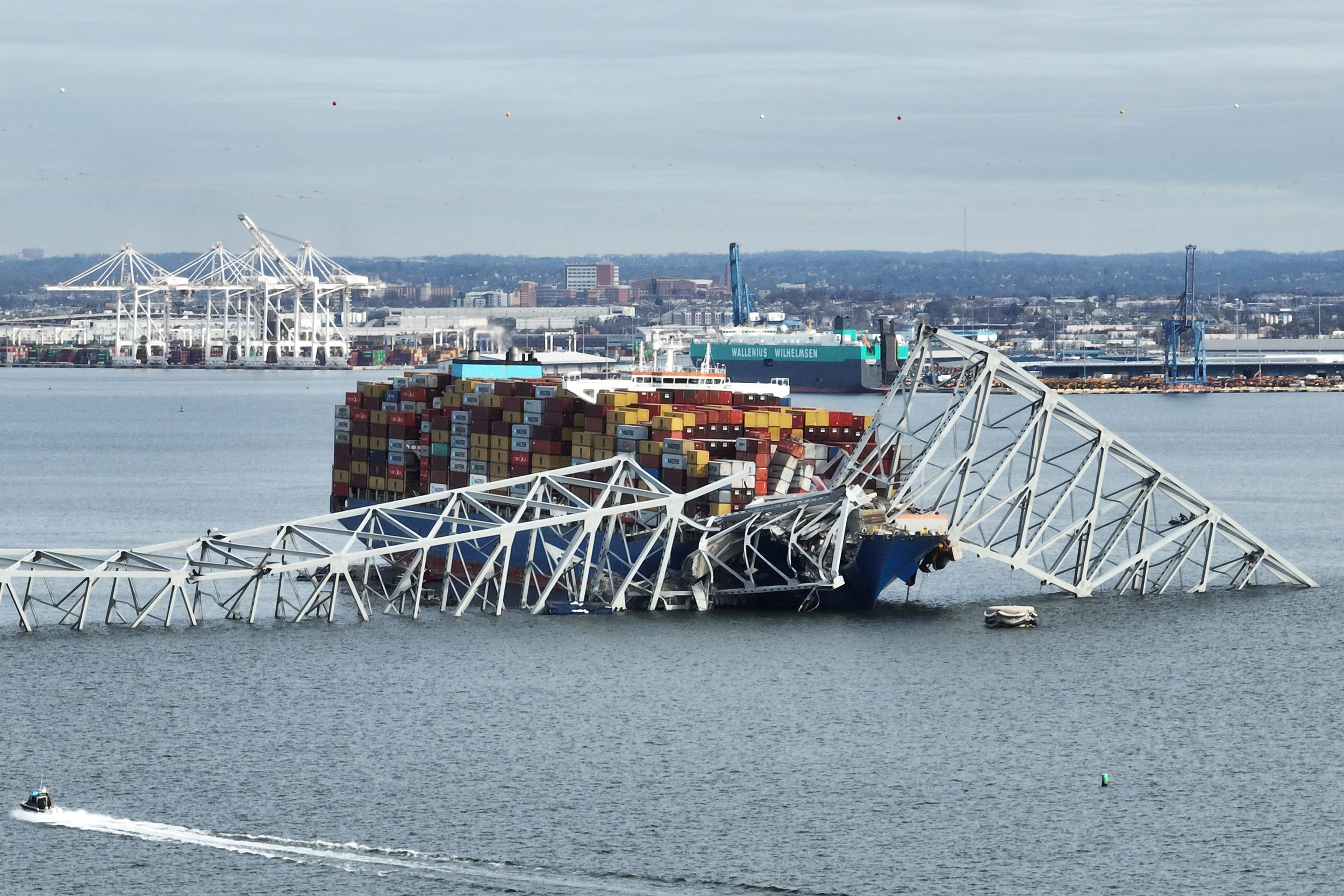 The steel frame of the collapsed Francis Scott Key Bridge sits on top of a container ship, in Baltimore