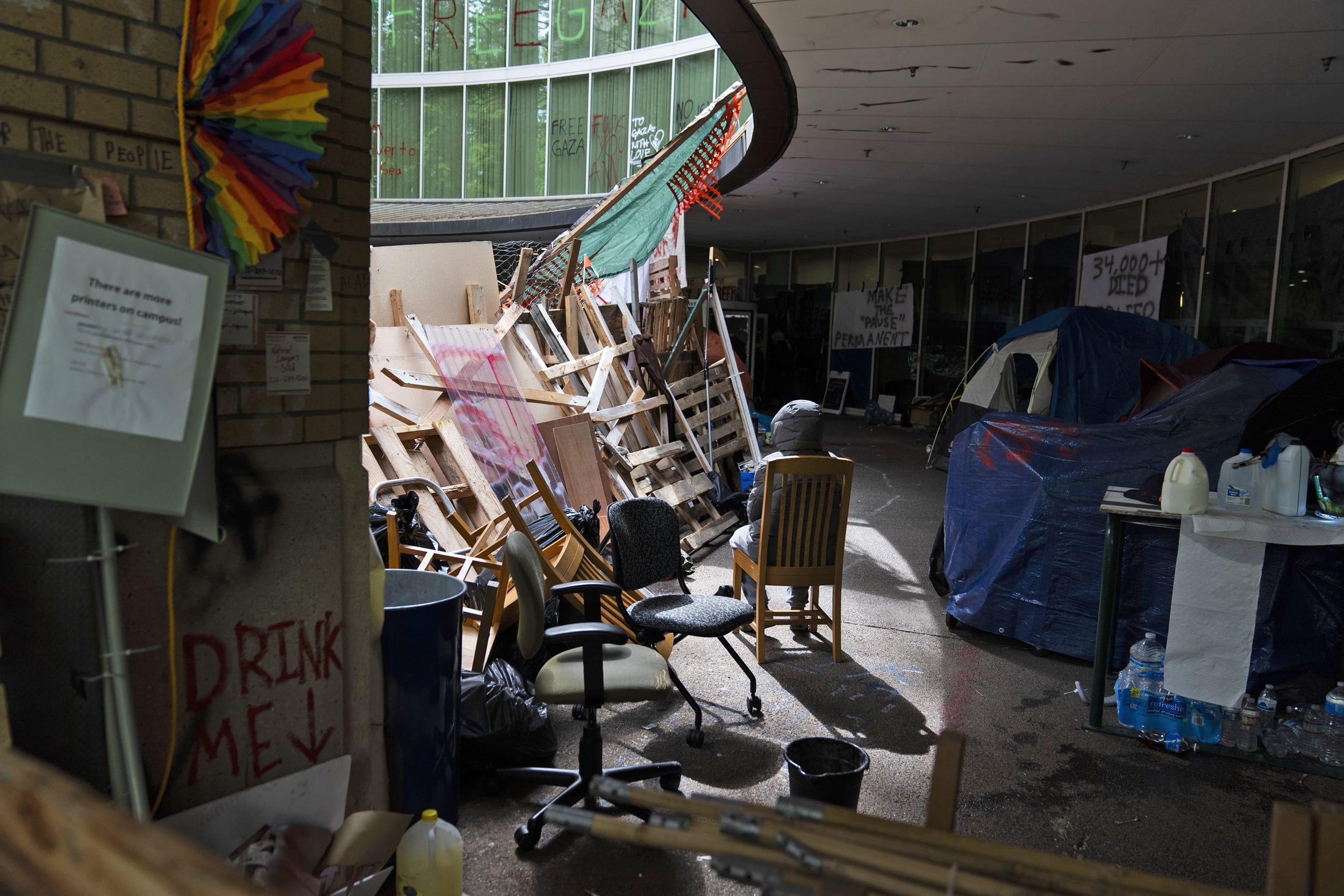 A pro-Palestinian protester sits near a barricade atPortland State University