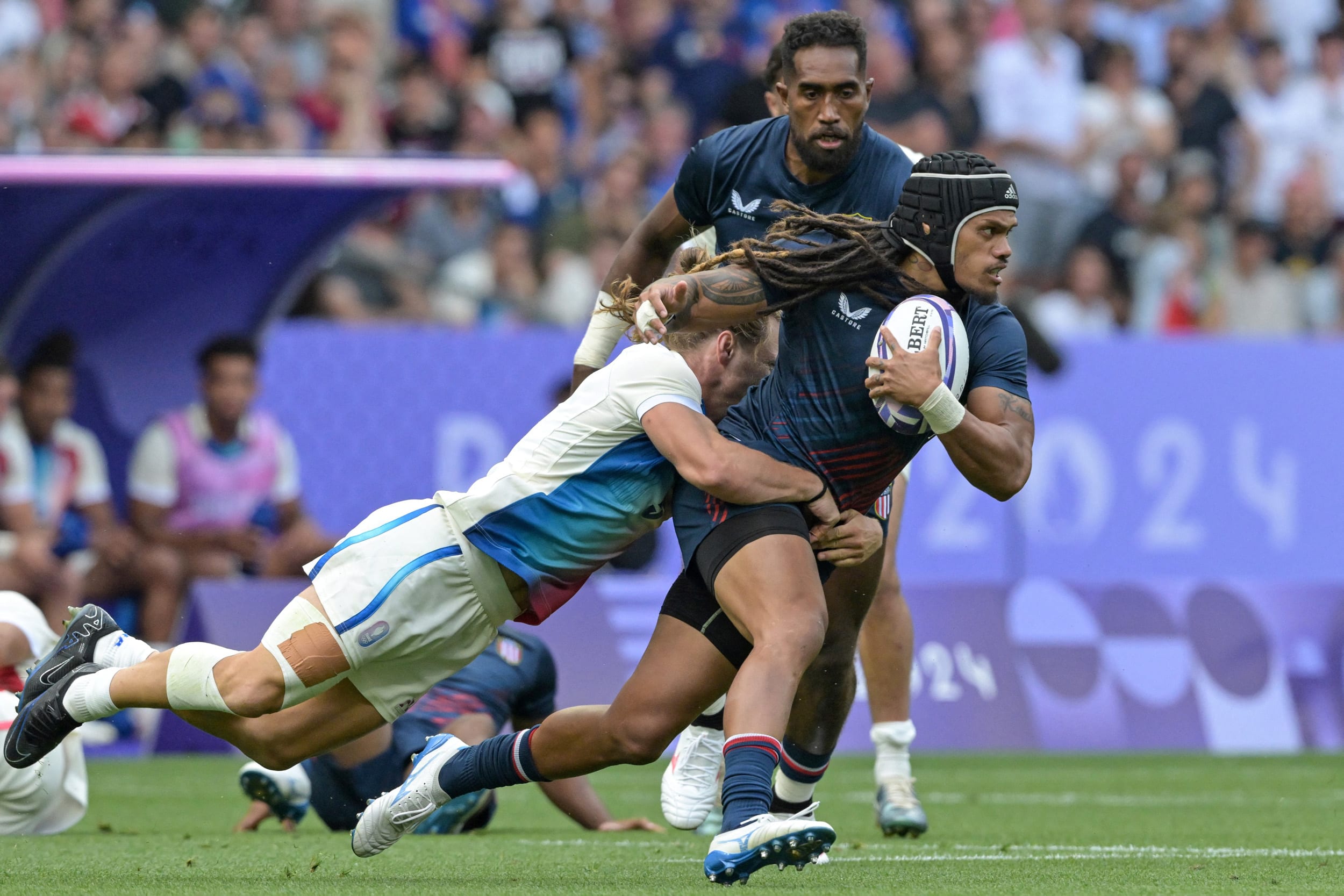 Team USA's Maka Unufe is tackled by France's Stephen Parez Edo Martin during the men's pool C rugby sevens match at the Paris 2024 Olympic Games on July 24.