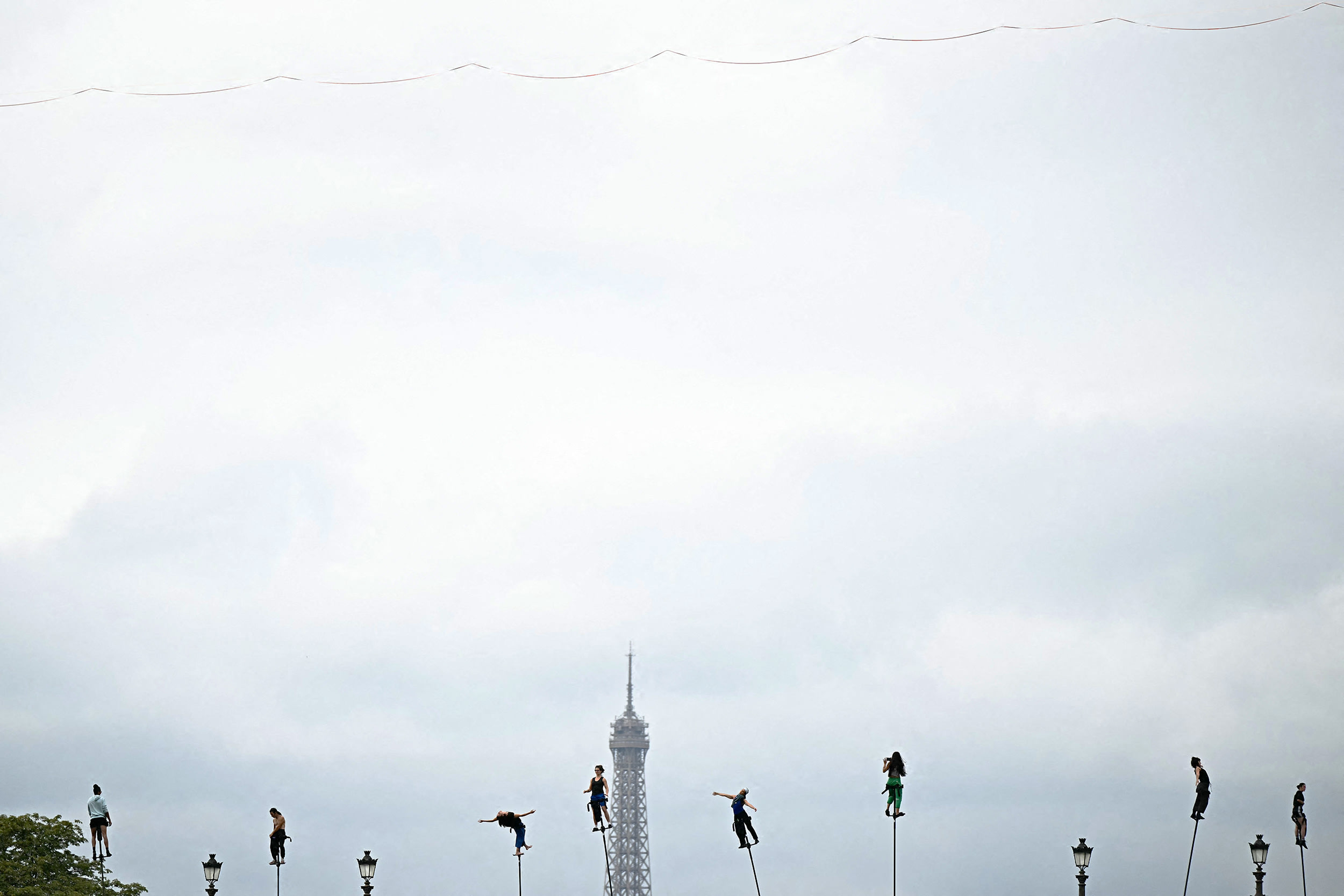 Dancers rehearse before the opening ceremony of the Paris 2024 Olympic Games in Paris on July 26, 2024, with the top of the Eiffel tower in the background. 