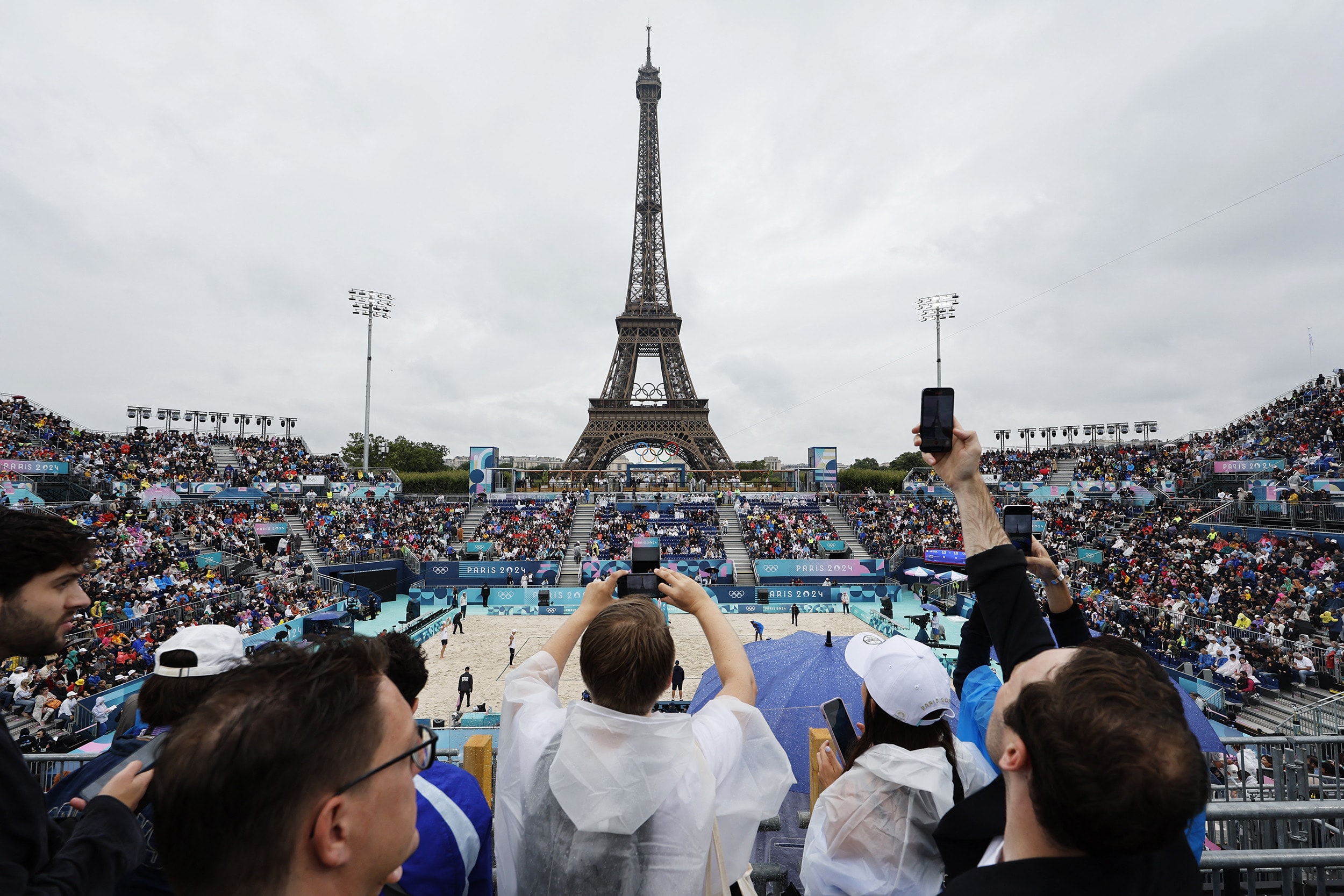 Spectator take pictures in the men's pool D beach volleyball match between USA and Cuba during the Paris 2024 Olympic Games at the Eiffel Tower Stadium in Paris on July 27, 2024.