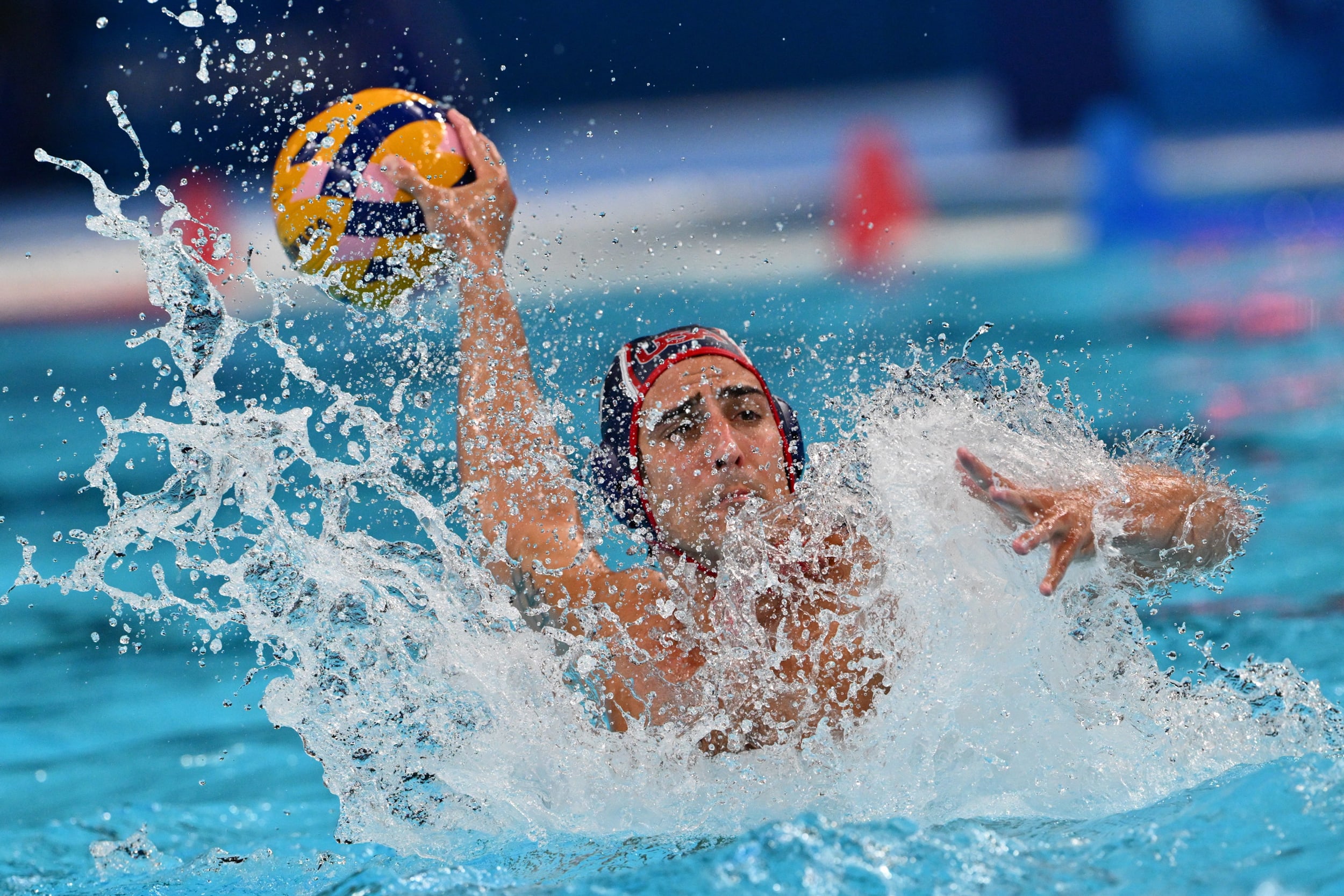 Luca Cupido of the U.S. shoots the ball in the men's water polo semifinal match against Serbia on Aug. 9, 2024 at the Paris Olympics.