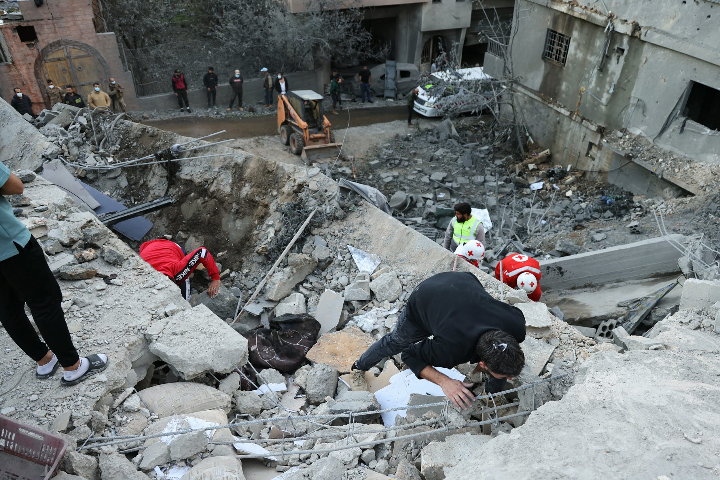 First responders and locals search through the rubble of a building destroyed by an Israeli airstrike in the village of Shebaa in southern Lebanon on September 27, 2024.