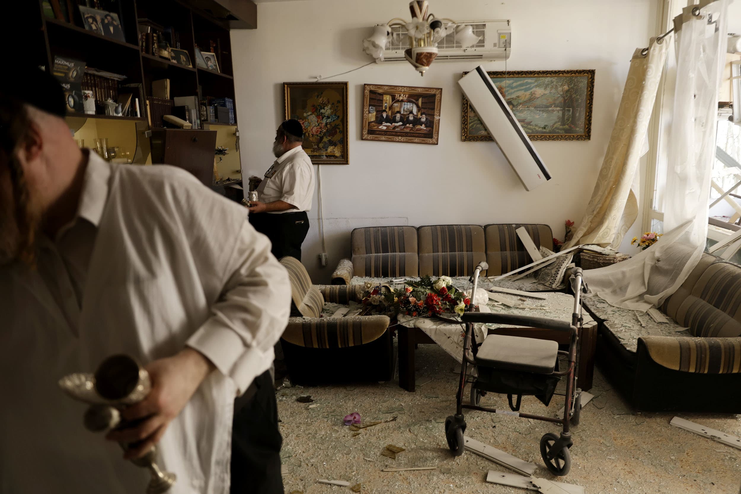 Residents inspect damage on a residential building hit by a rocket on Oct. 8, 2024 in Kiryat Yam near Haifa, Israel.