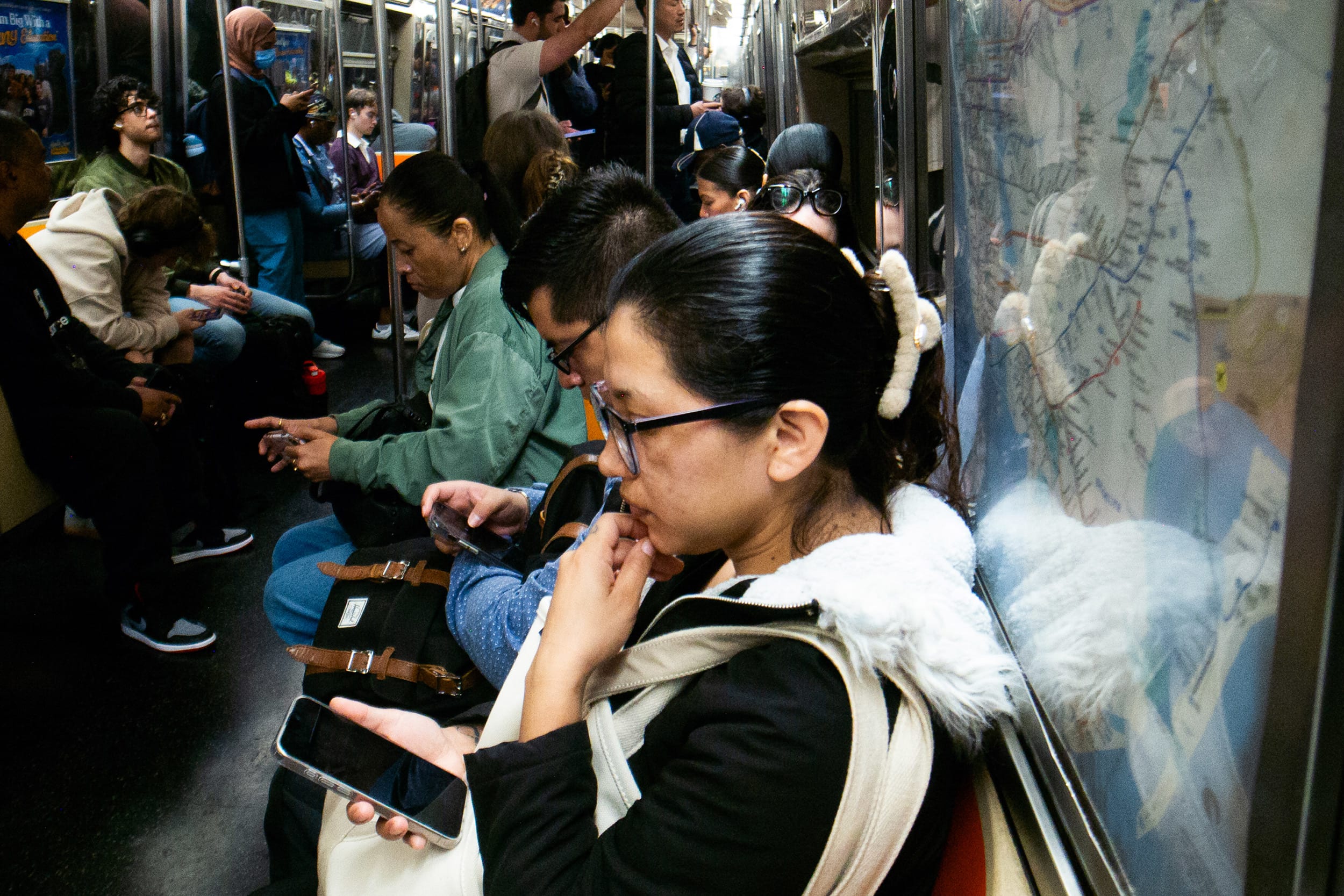 Commuters look at their cell phones