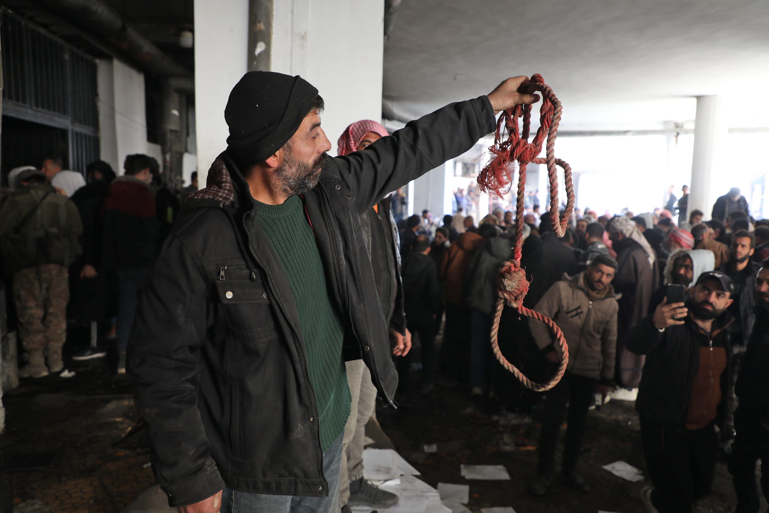 A man holds up rope at Saydnaya prison