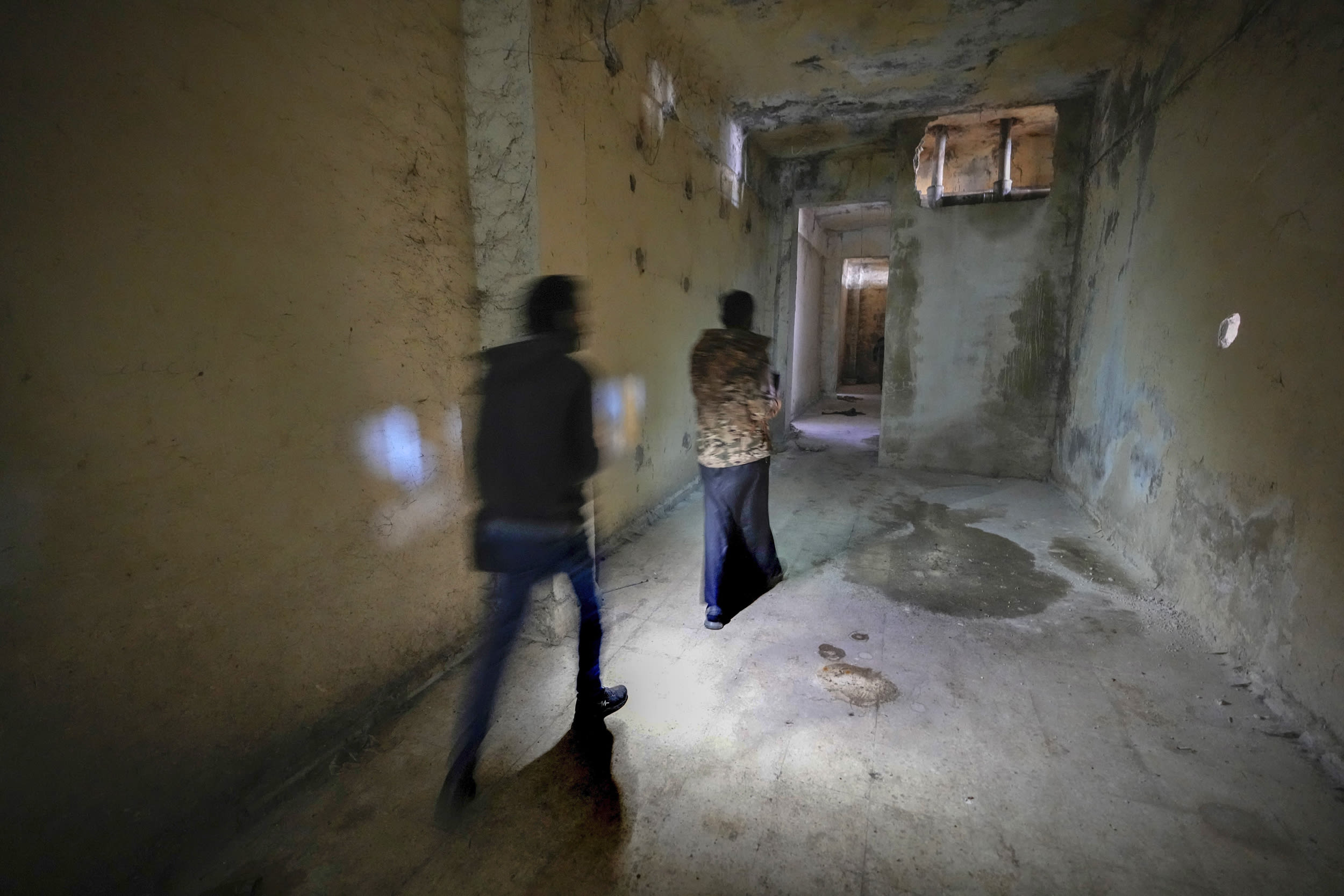 People walks through a corridor of the Saydnaya prison