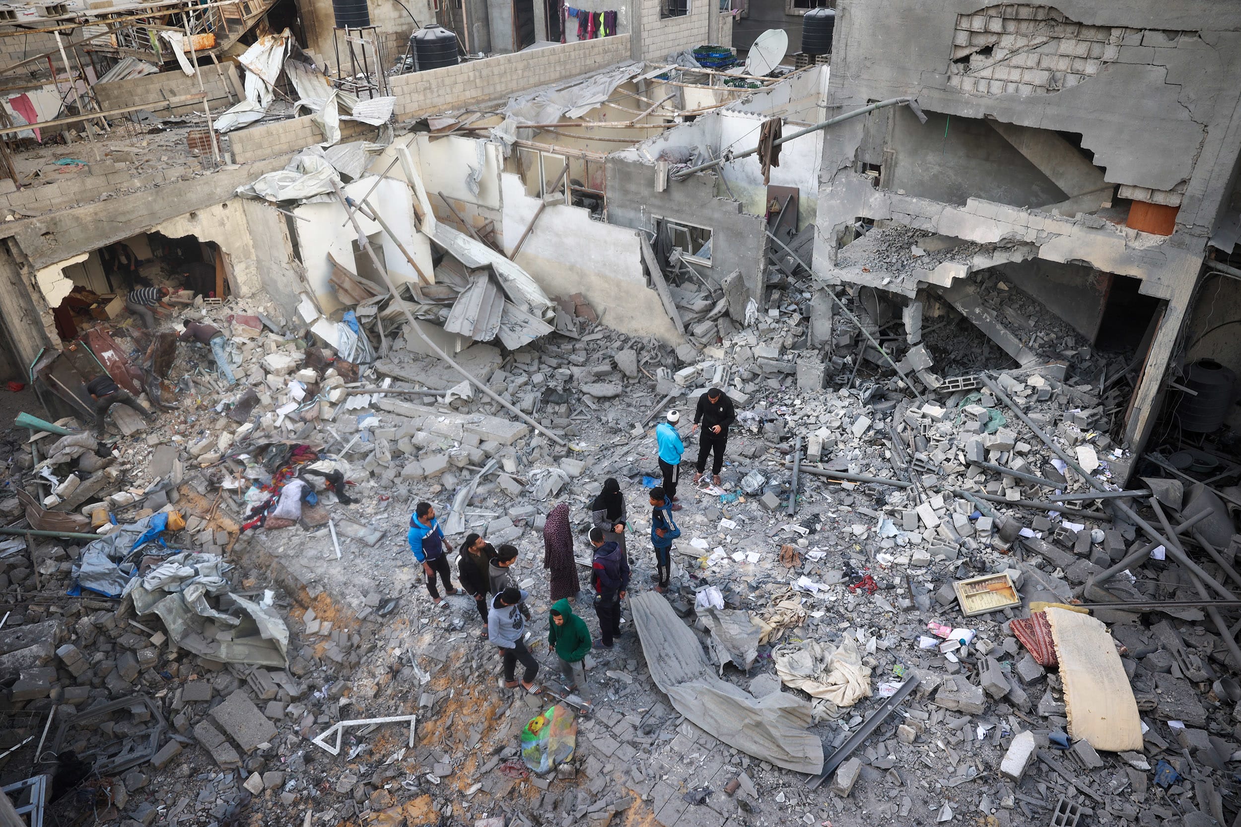 Residents look at the remains of their homes, destroyed in an Israeli strike, at the Nuseirat refugee camp in the central Gaza Strip on March 18, 2025. 