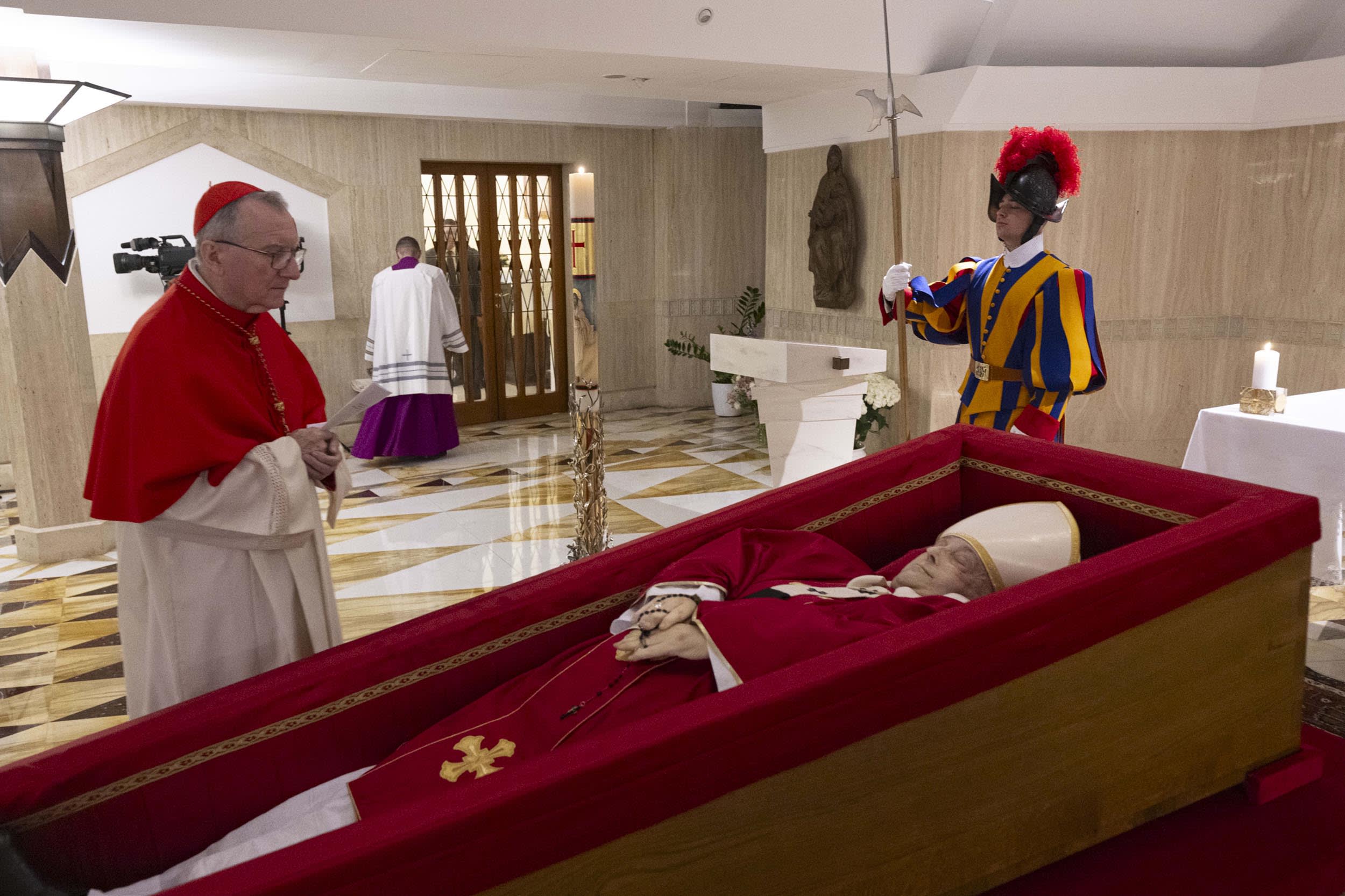 Vatican Secretary of State Cardinal Pietro Parolin, left, prays in front of the body of Pope Francis inside his private chapel at the Vatican, Monday, April 21, 2025. 