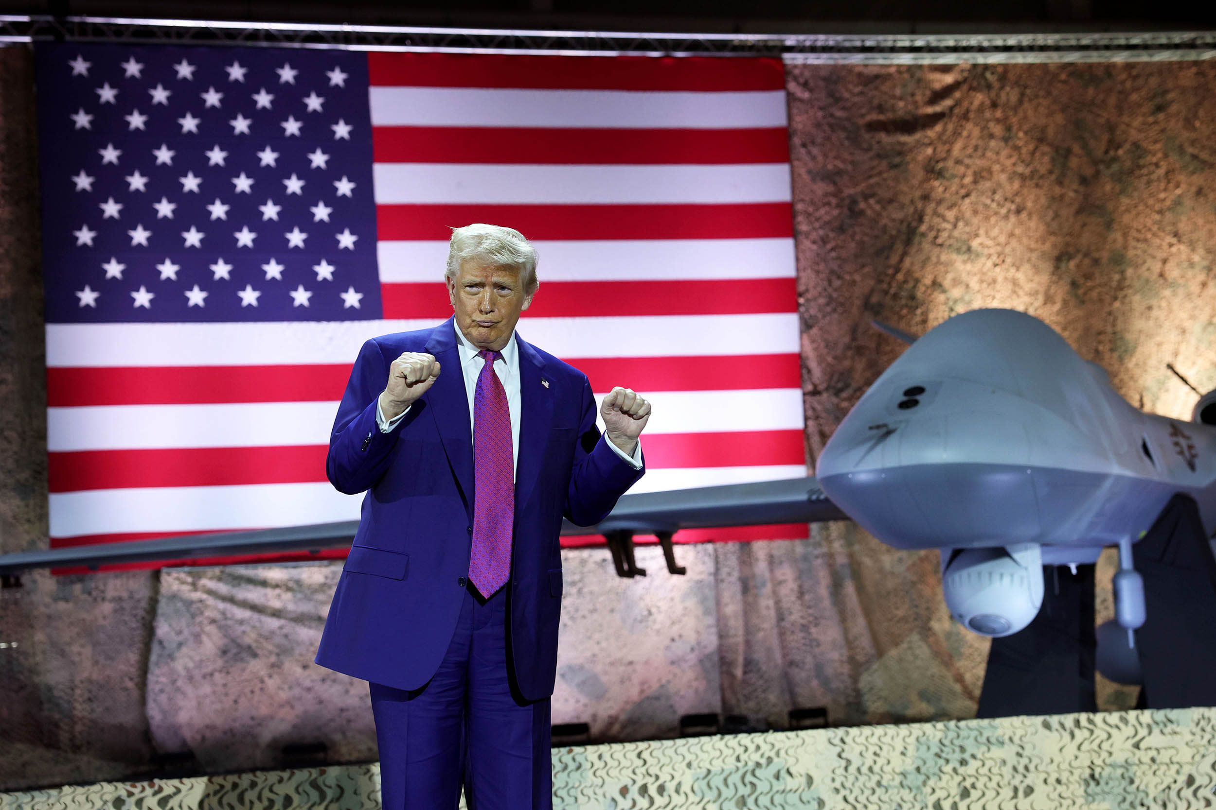 President Donald Trump gestures on stage