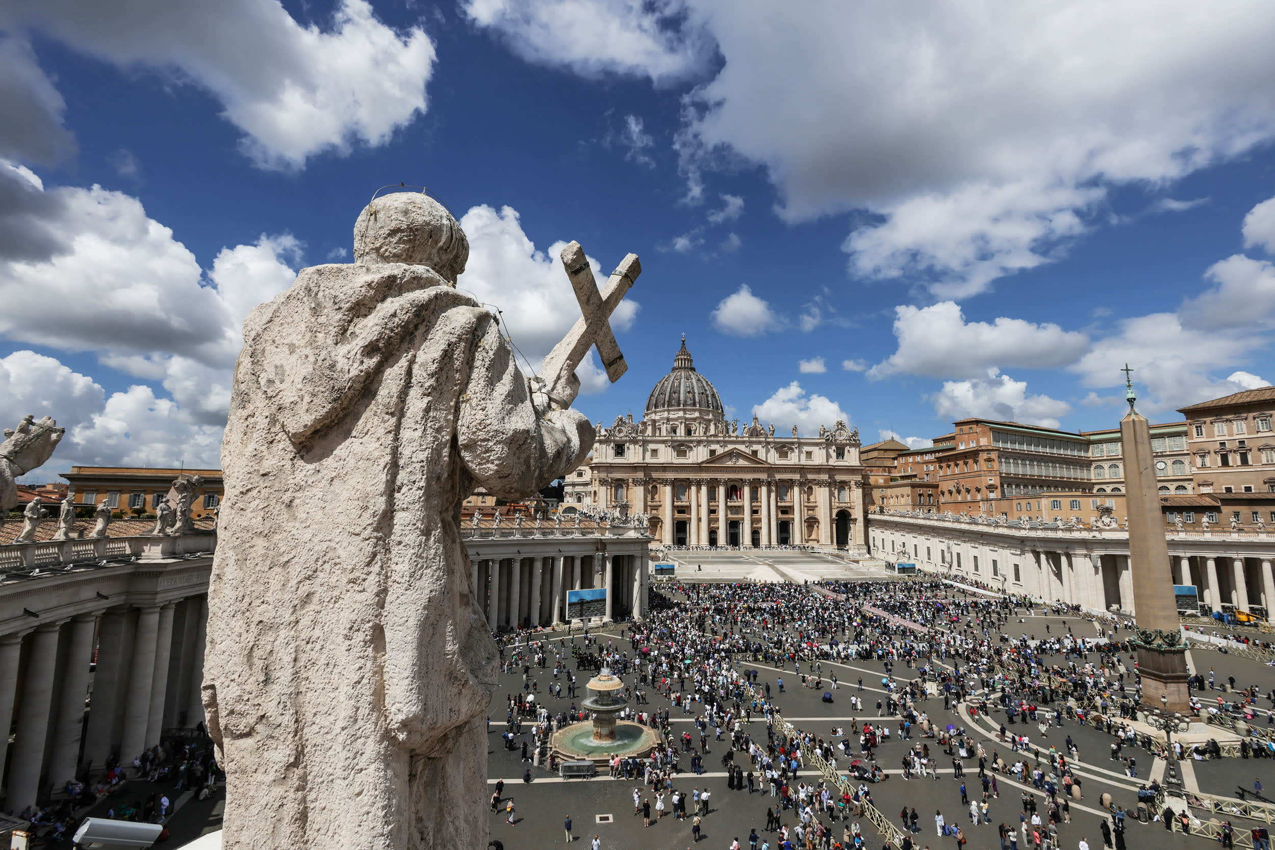 People gather near St. Peter's Basilica at the Vatican