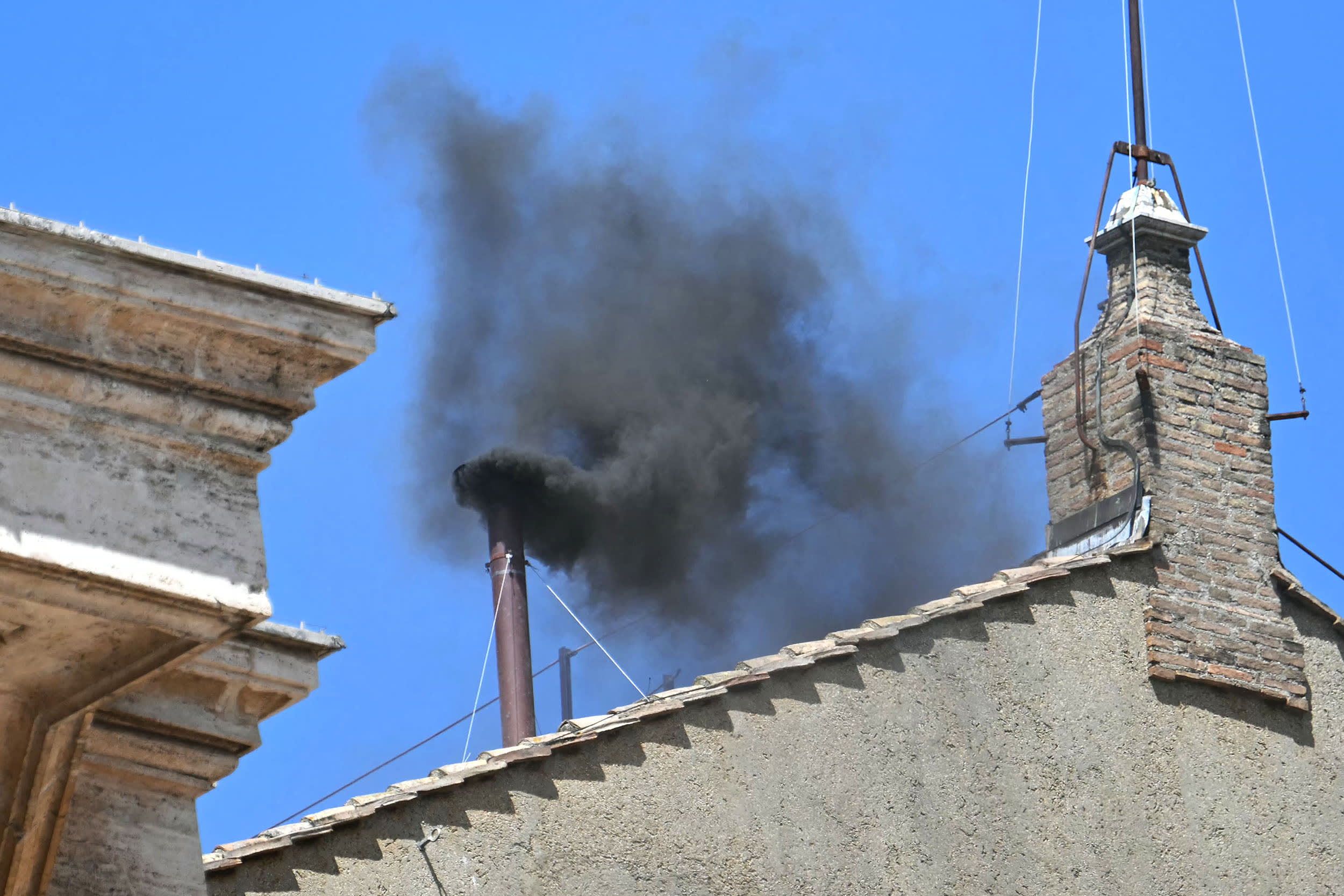Black smoke rising from the chimney of the Sistine Chapel signalling that cardinals failed to elect a new pope during their conclave in the Vatican.