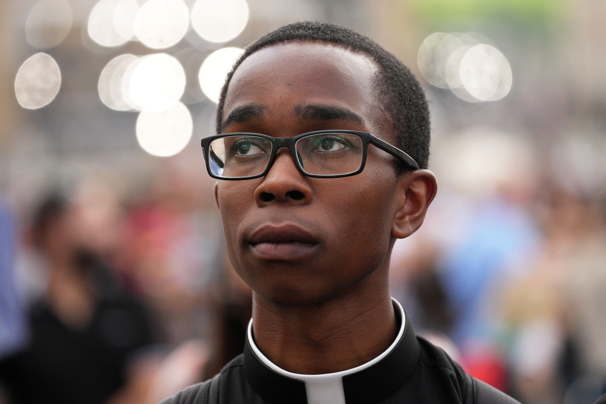 A priest watches and waits for smoke from the chimney of the Sistine Chapel as Catholic cardinals gather for a second day to elect a new pope on May 8, 2025 in Vatican City, Vatican. 