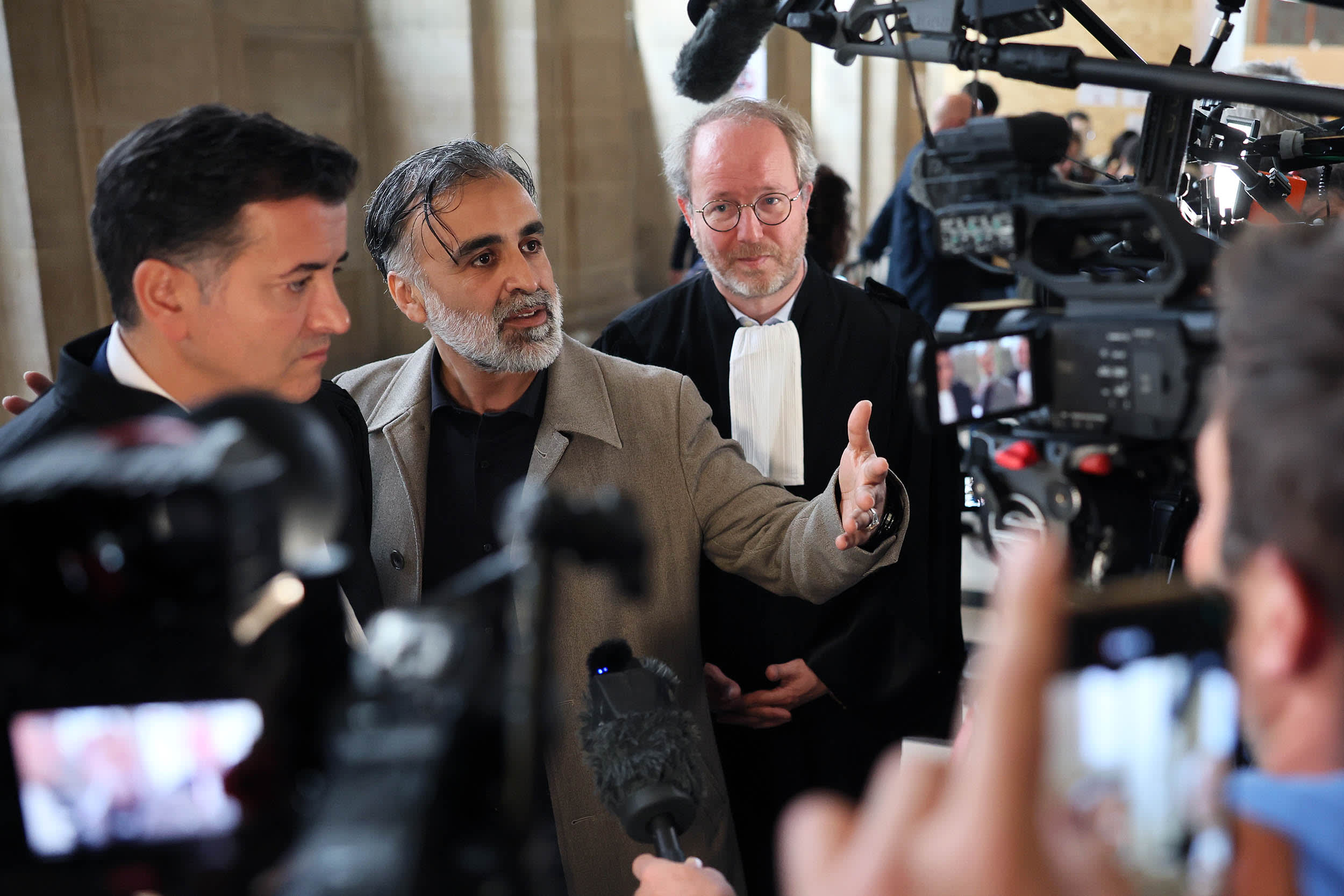 Plaintiff Abderrahmane Ouatiki, and his lawyer Henri De Beauregard, speaks to the press at the Palais de Justice of Paris