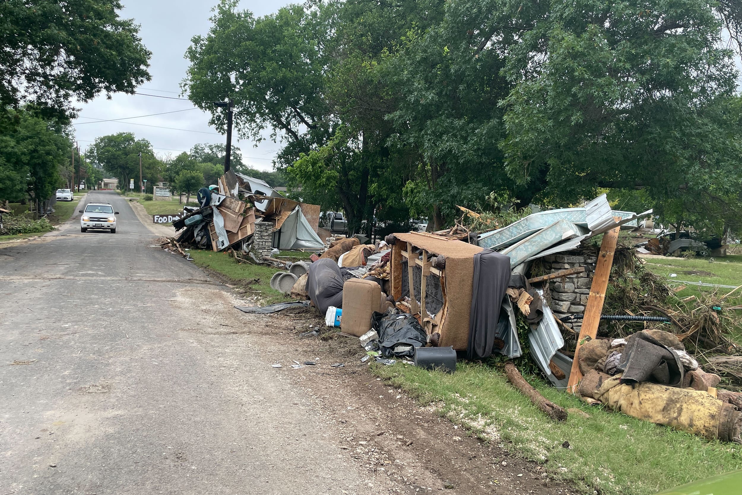 Piles of furniture lay on the ground next to a road in Hunt, Texas, on Sunday, July 5, 2025. Hunt is home to Camp Mystic, the Christian summer camp for girls that was rocked by severe flooding, with 27 children still missing as of Sunday night.