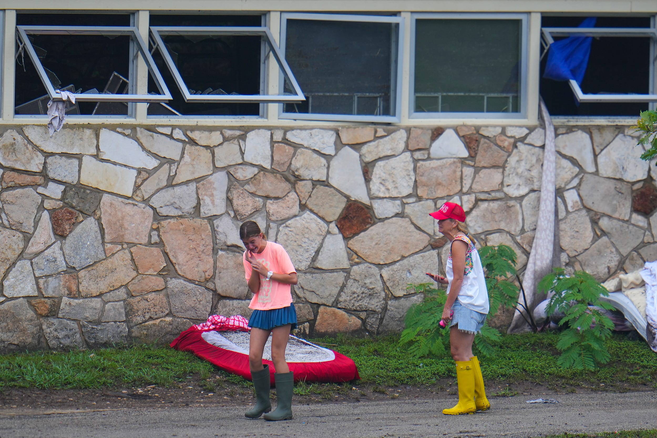 People react as they inspect an area outside sleeping quarters at Camp Mystic along the banks of the Guadalupe River after a flash flood swept through the area Sunday, July 6, 2025, in Hunt, Texas.