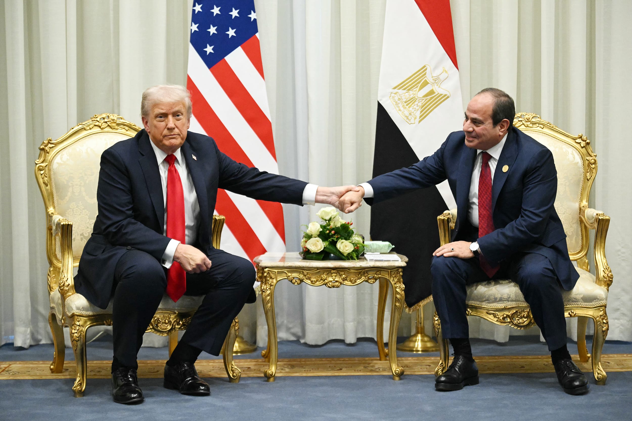 President Donald Trump holds Egypt's President Abdel Fattah el-Sissi's hand.