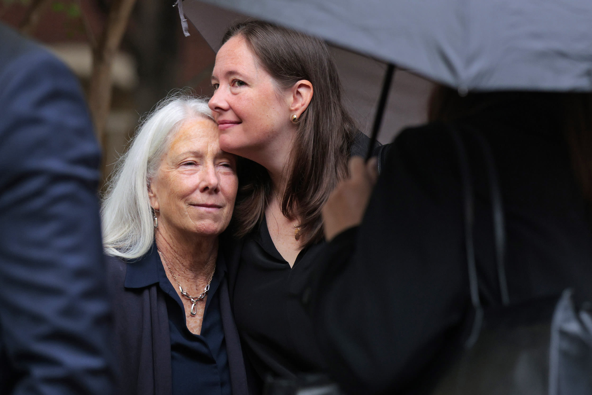 Patrice Failor, wife of former FBI director James Comey, is embraced by her daughter Maurene Comey as they arrive at court.